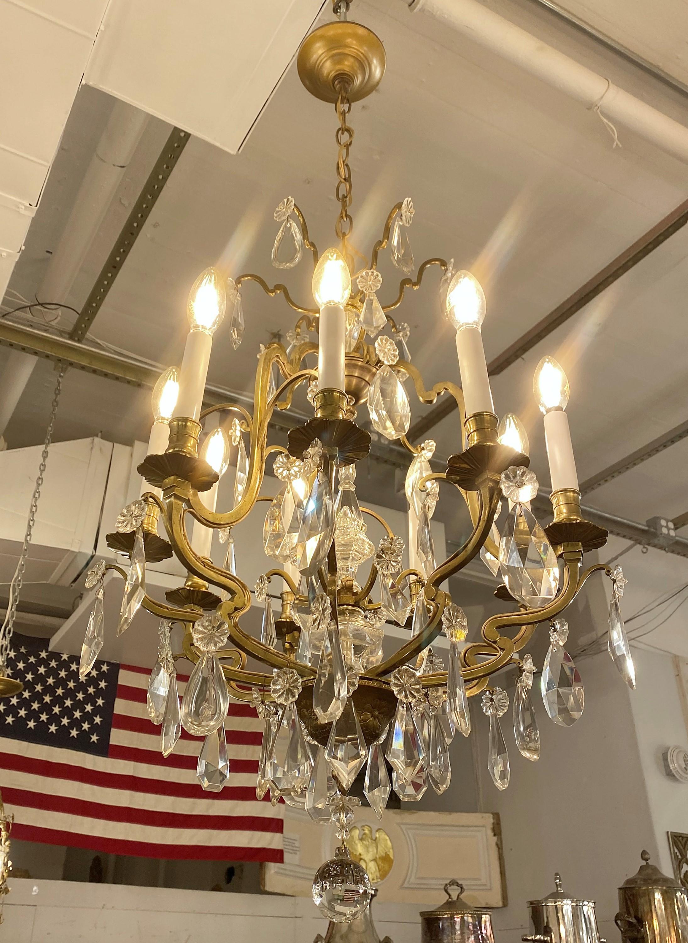 20th century petit bronze and crystal chandelier done in a Louis XV style. Loaded with crystals. Takes 9 normal chandelier style light bulbs. Cleaned and restored. This light is wired and ready to ship. Please note, this item is located in one of