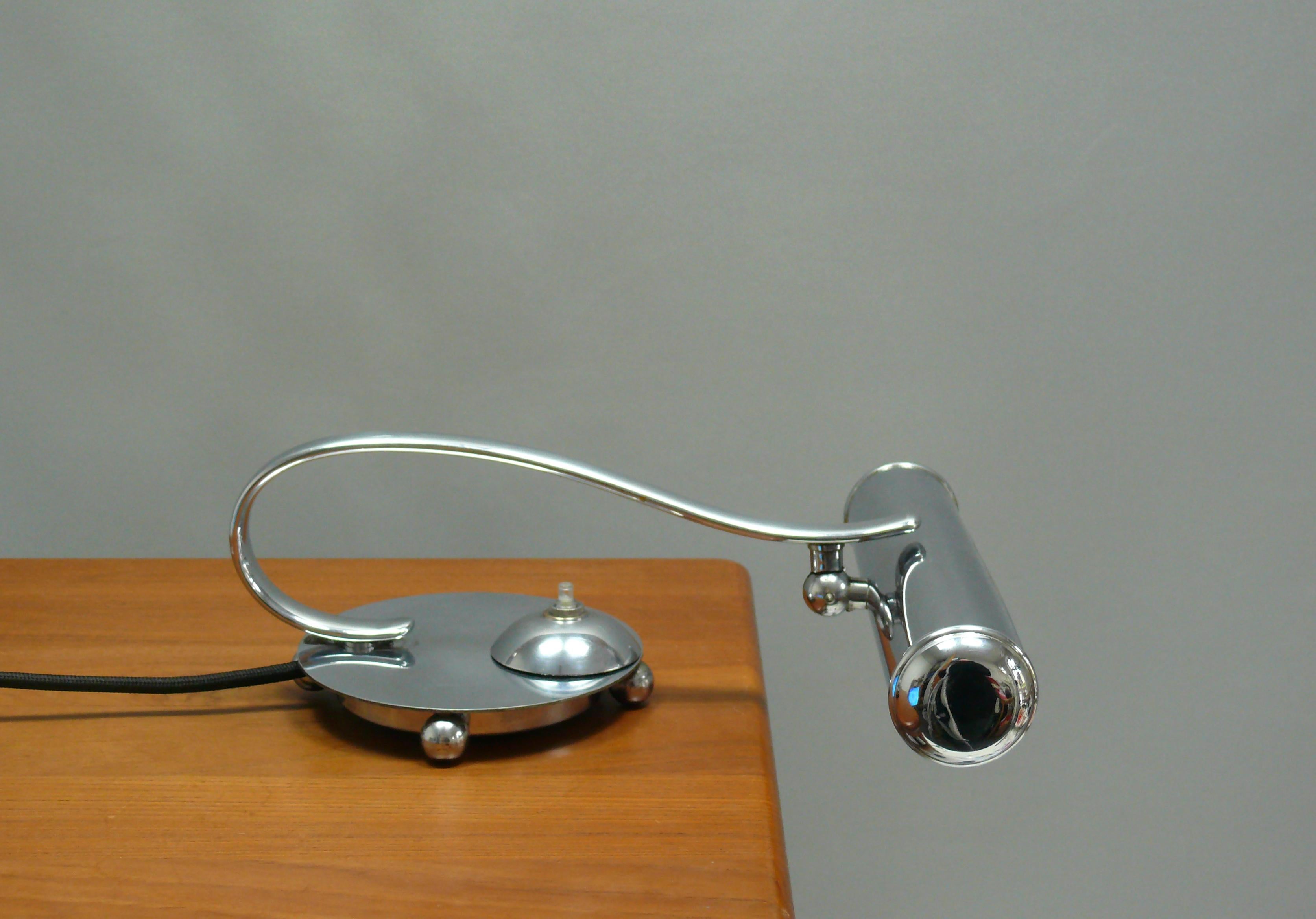 Extraordinary Art Deco piano lamp from the 1930s, completely chrome-plated. The lamp impresses with its elegant shape and good condition: the round base with the slightly protruding cover plate is supported by 4 spherical feet. A hemispherical