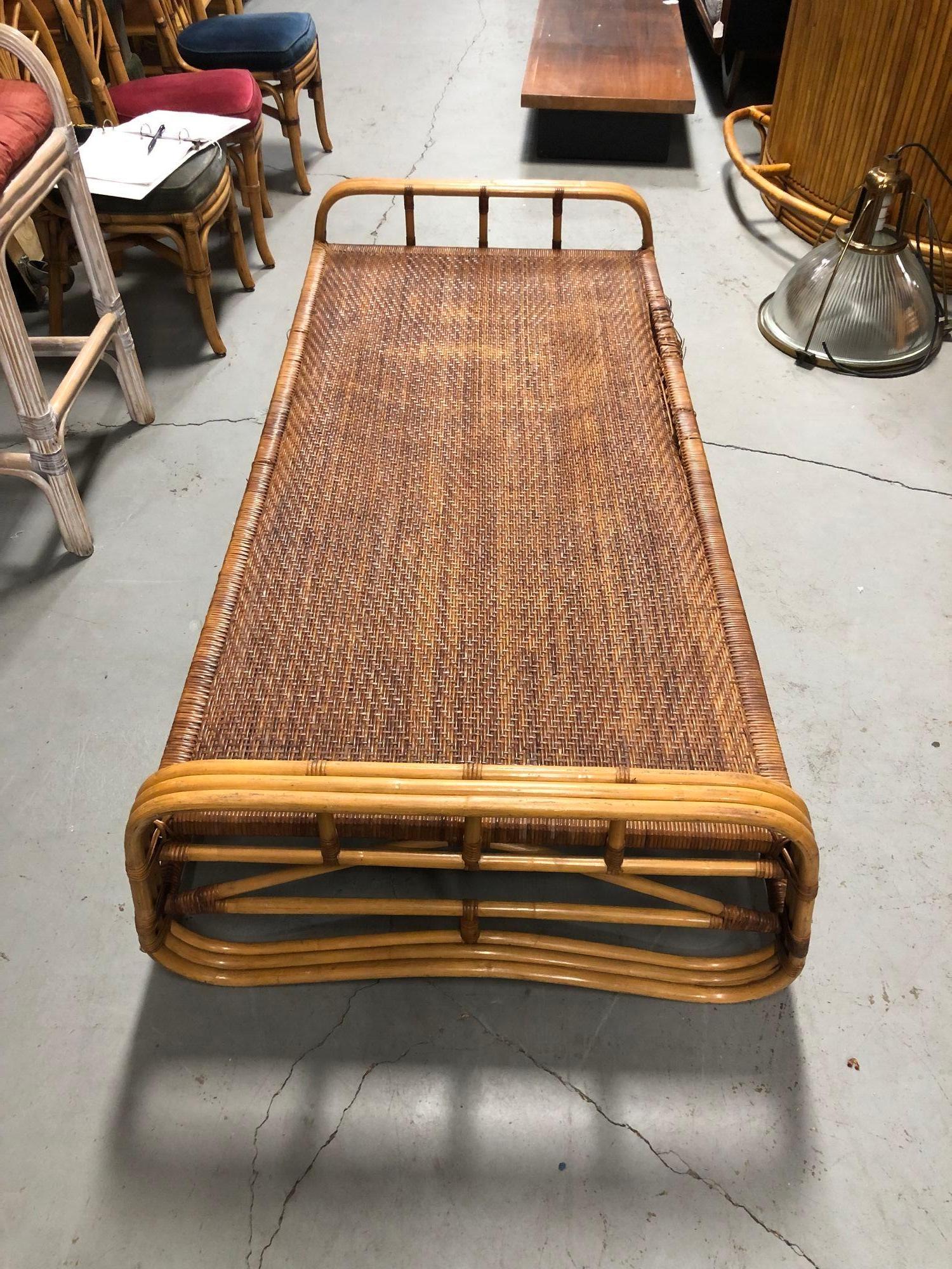 This restored rattan cot-style day bed frame seamlessly melds vintage charm with modern comfort. Meticulously restored, its rattan construction exudes timeless elegance, offering a cozy retreat. A blend of history and contemporary appeal, this piece