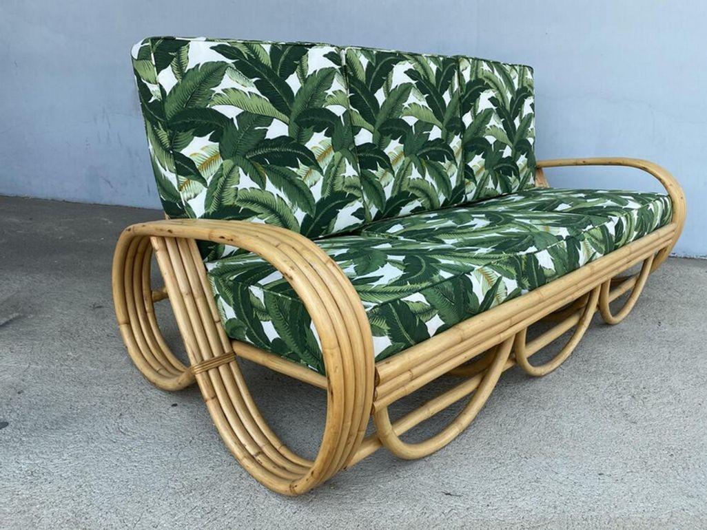 Four-strand 3/4 reverse pretzel rattan sofa featuring a decorative scalloped detail on the base.

Dimensions: 28