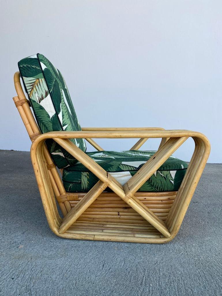 Conçue à la manière de Paul Frankl, cette chaise longue en rotin à cinq brins présente des accoudoirs carrés en forme de bretzel et une base classique en rotin empilé. Les coussins 