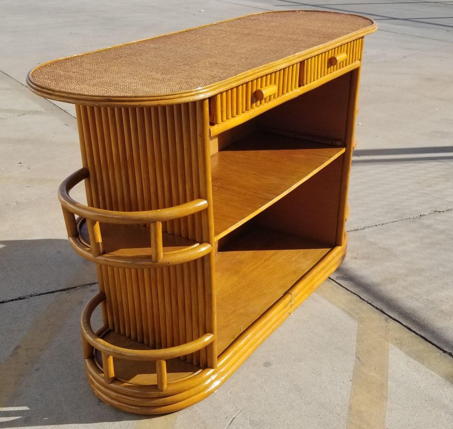 Beautifully restored rattan and mahogany mid-century dry bar featuring a textured mat top, side shelves, and stacked rattan sides. Add a touch of tropical tiki vibes to your entertaining space.

We only purchase and sell only the best and finest