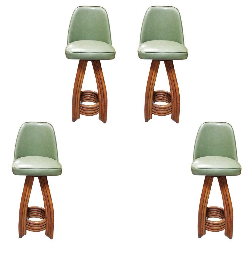 Revitalize your space with the timeless charm of an authentic Paul Frankl set made in 1936.

Meticulously restored, these four rattan bar stools showcase distinctive three-strand legs and a stacked rattan footrest base. The Avocado Green Naugahyde