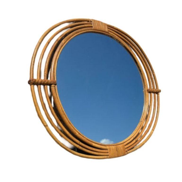 Elevate your decor with our restored rattan oval wall mirror featuring a reed rattan frame. Handcrafted and woven in the 1950s, this meticulously crafted piece blends natural elegance with vintage charm. The spirals add depth and style to any room.