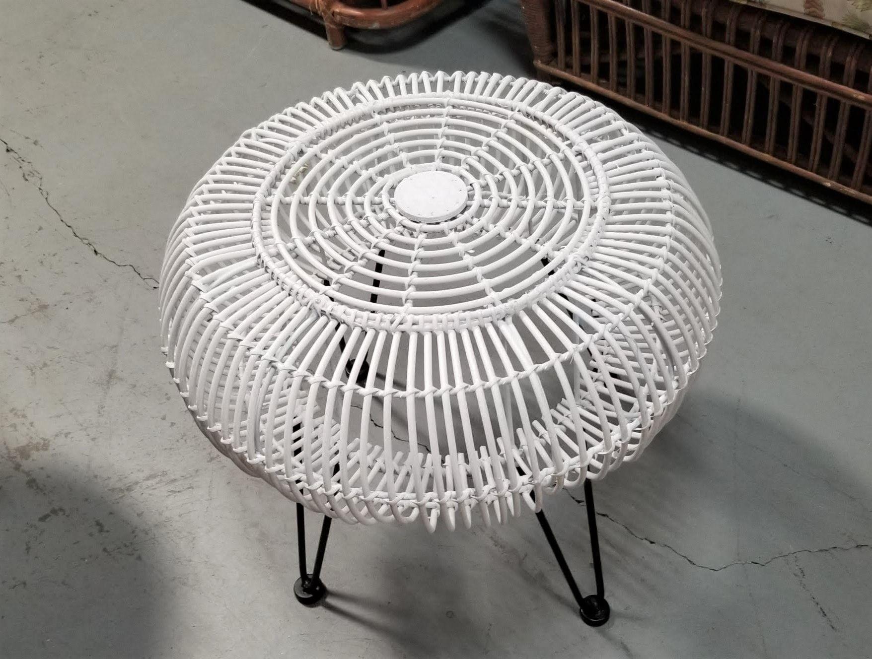 Restored reed rattan ottoman stool in white paint with iron hairpin legs. The stool was inspired by the Italian design coming up in the second half of the 20th century with its rounded stick rattan skeleton design but a distinctly American influence