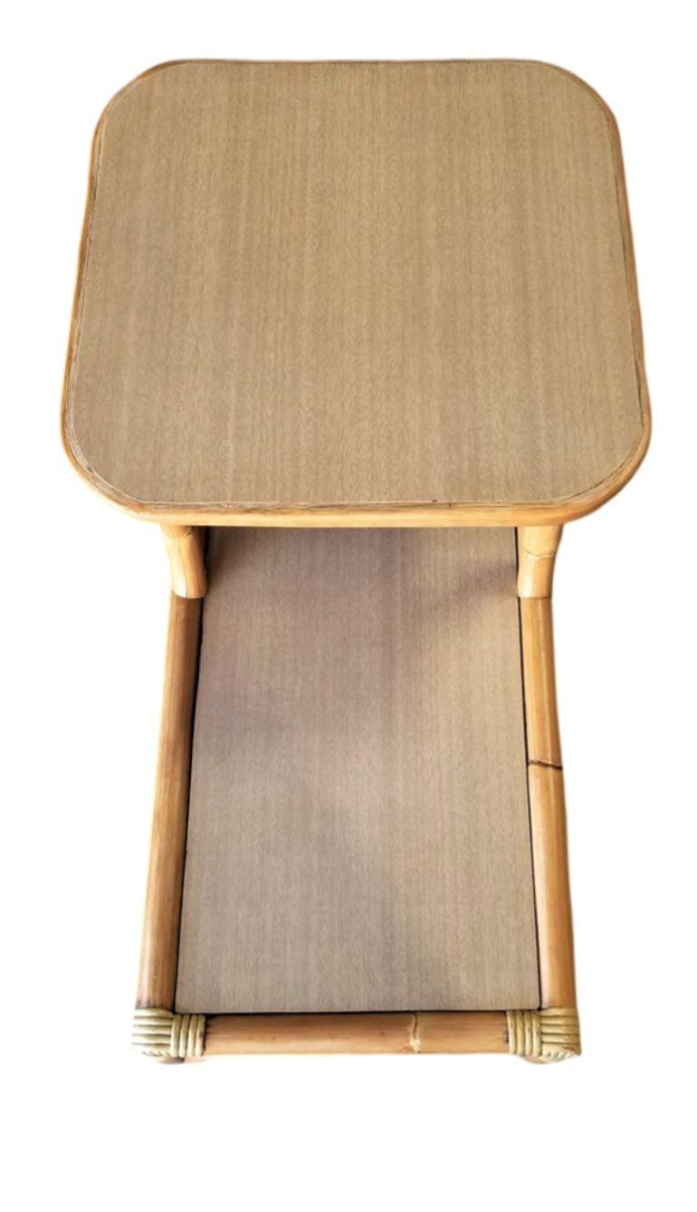 This beautifully restored Paul Frankl-inspired set of 2 restored rattan side tables with 2-tier table tops each featuring a soft beige Formica top is perfect alongside your bed or sofa. The set is reminiscent of the styling made famous by Paul T