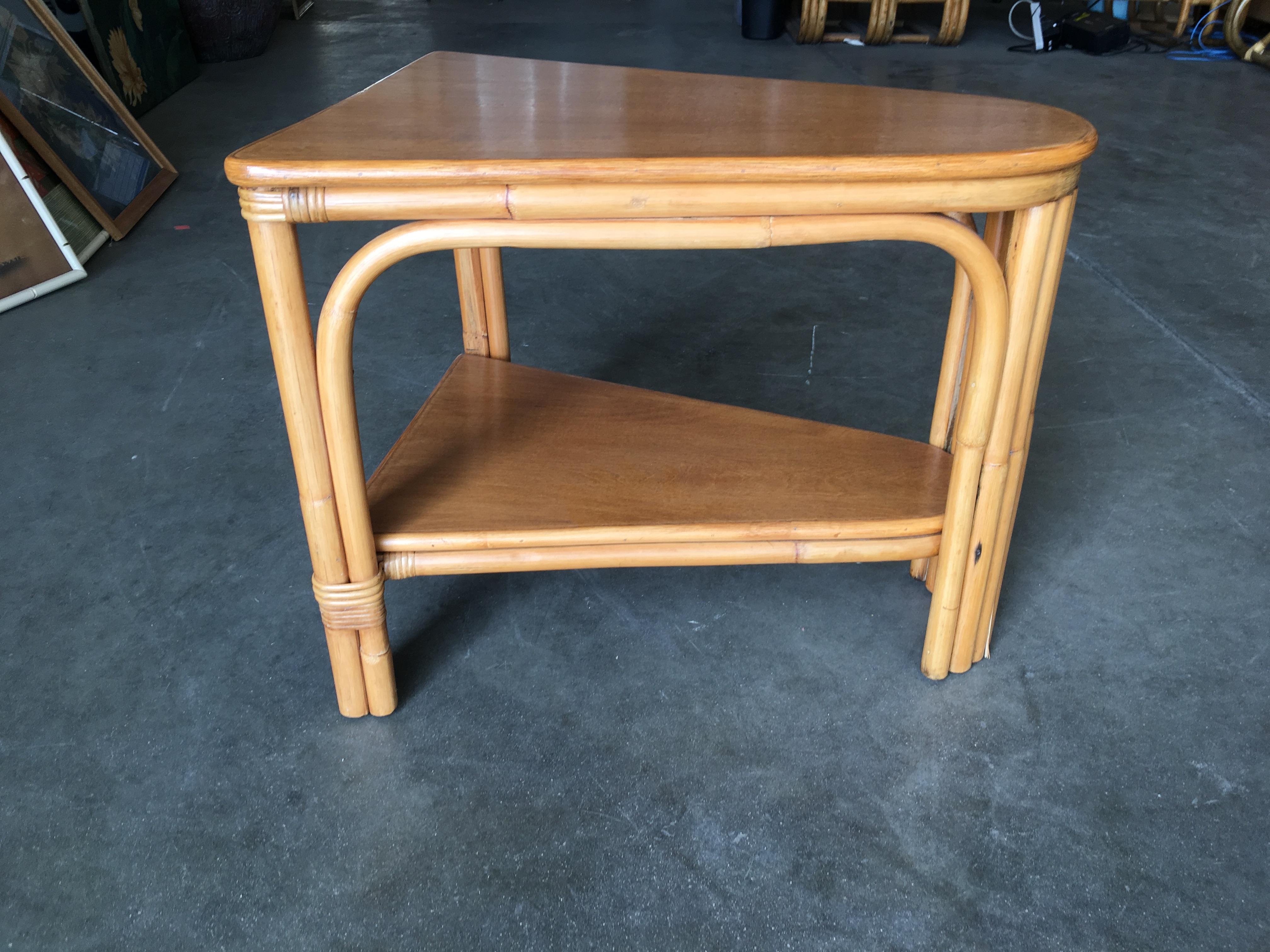 Vintage pole rattan leg two-tier triangle wedge table with two-tier mahogany tops. Great for use as a drinks table. 

All pieces listed are professionally restored.
All our rattan, bamboo and wicker furniture has been painstakingly refurbished to