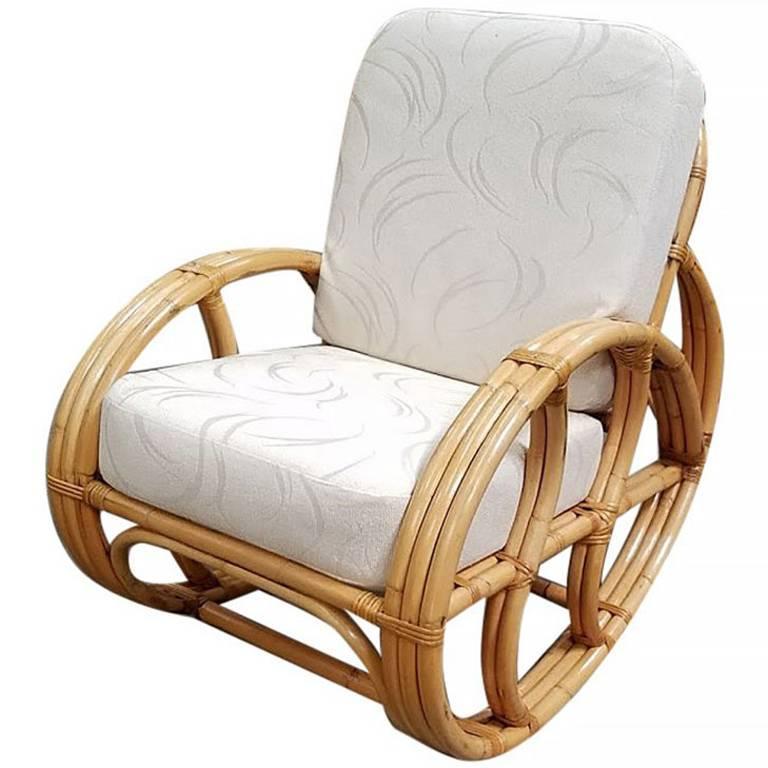 A rare three-strand pretzel arm rattan rocking chair with white cushions. This chair features a steam bent rattan frame.

This rare pretzel rocking chair was made in the late 1940s. I sold this chair originally in 1987 covered in this fabulous