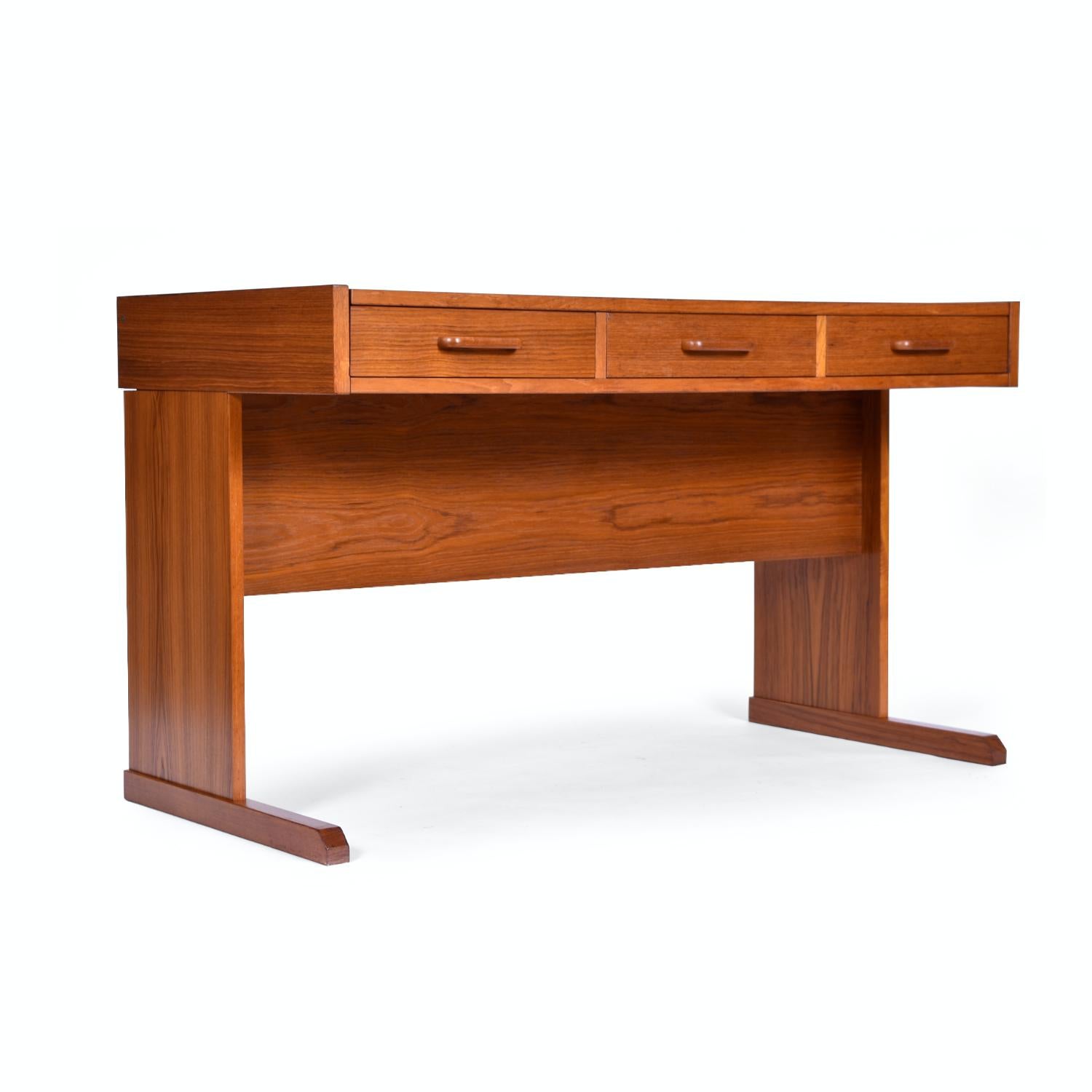 Restored vintage Danish teak desk by Vi-Ma. The unassuming desk holds a very clever secret. Slide the table top to reveal a filing cabinet space. The standard size filing cabinet is the perfect space saving solution for your home office. Watch our