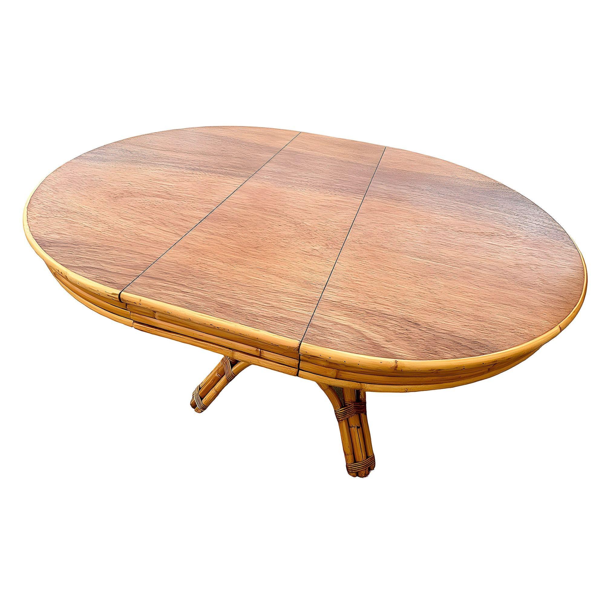 Cette table ronde en rotin d'inspiration Paul Frankl, magnifiquement restaurée et dotée d'un plateau en acajou d'origine, est équipée d'une rallonge permettant de passer facilement d'une table de 4 à 8 personnes. La table est dotée d'une base en