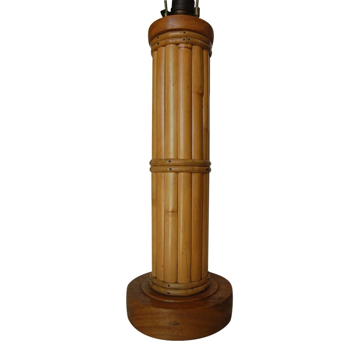 Lampe de table ronde en rotin restaurée, datant du milieu du siècle, composée de treize tiges décoratives en rotin centrées autour d'un poteau en rotin, le tout fixé à une base circulaire en bois avec des enveloppes fantaisistes.
Mesure 4