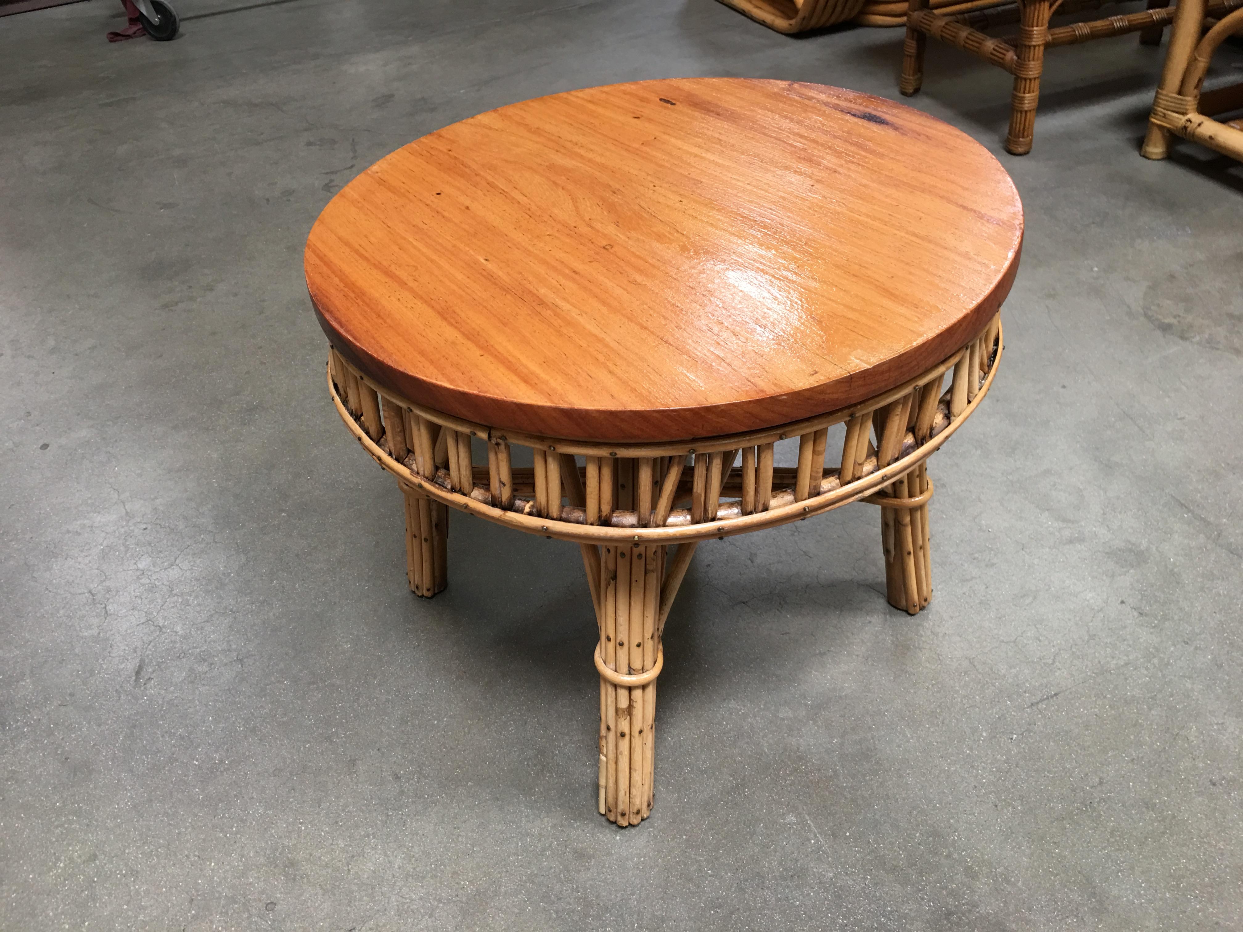 Round stick rattan coffee table with mahogany top featuring brass nail head accents, circa 194. 

Designed in the manner of Paul Frankl.

Restored to new for you.

All rattan, bamboo and wicker furniture has been painstakingly refurbished to the