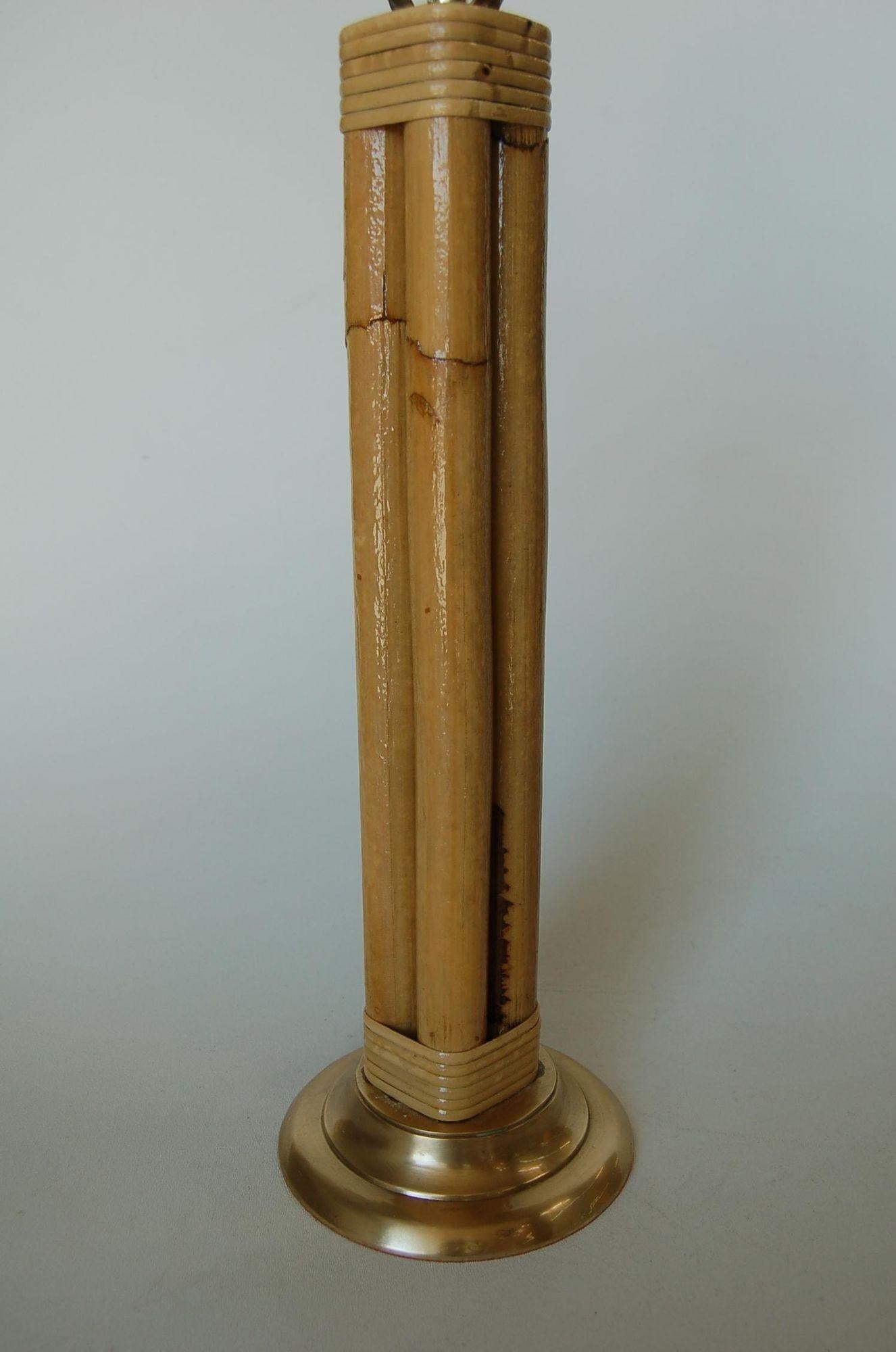 This beautifully restored Paul Frankl-inspired midcentury round rattan table lamp featuring four decorative rattan poles centered around a rattan post all fixed to a brass circular base with fancy wrapping, circa 1950. 

Measures 6