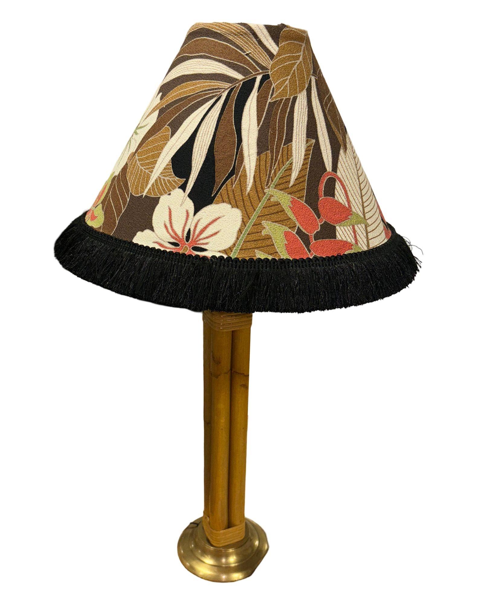 This beautifully restored Paul Frankl-inspired Mid-century round rattan table lamp features four decorative rattan poles centered around a rattan post all fixed to a brass circular base with fancy wrapping, circa 1950. 

Measures 6