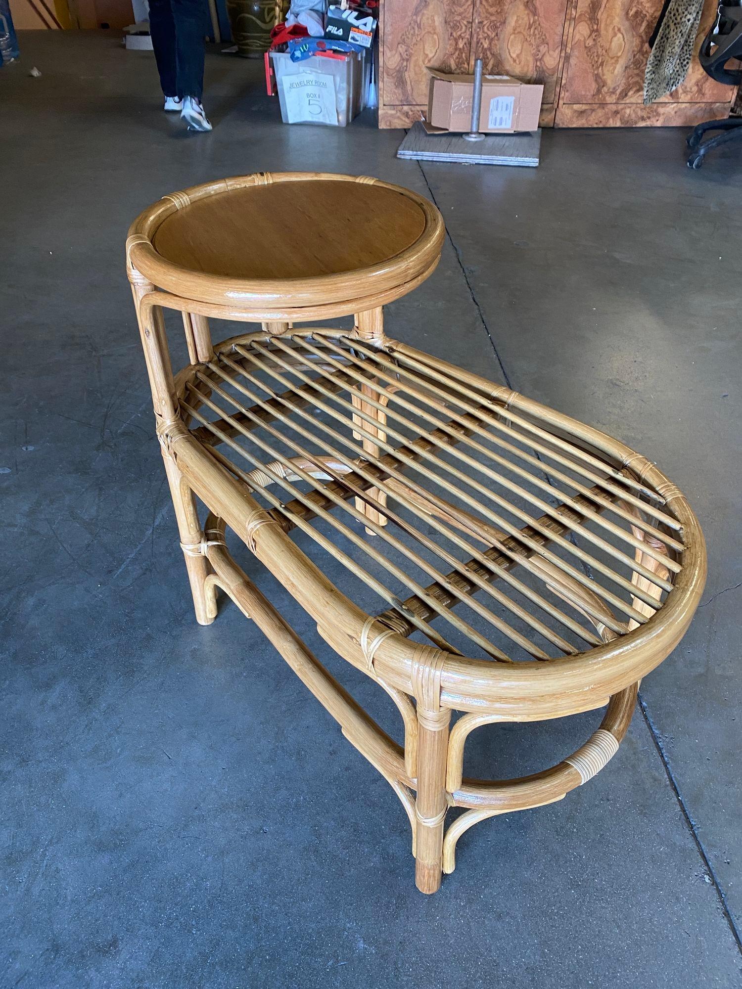 Pair of mid-century single-strand two-tier rattan side tables with stick rattan grill bottom tier and wood top tier. Each table features wicker-wrapped arched accents with a unique wide oval shape.
We only purchase and sell only the best and finest