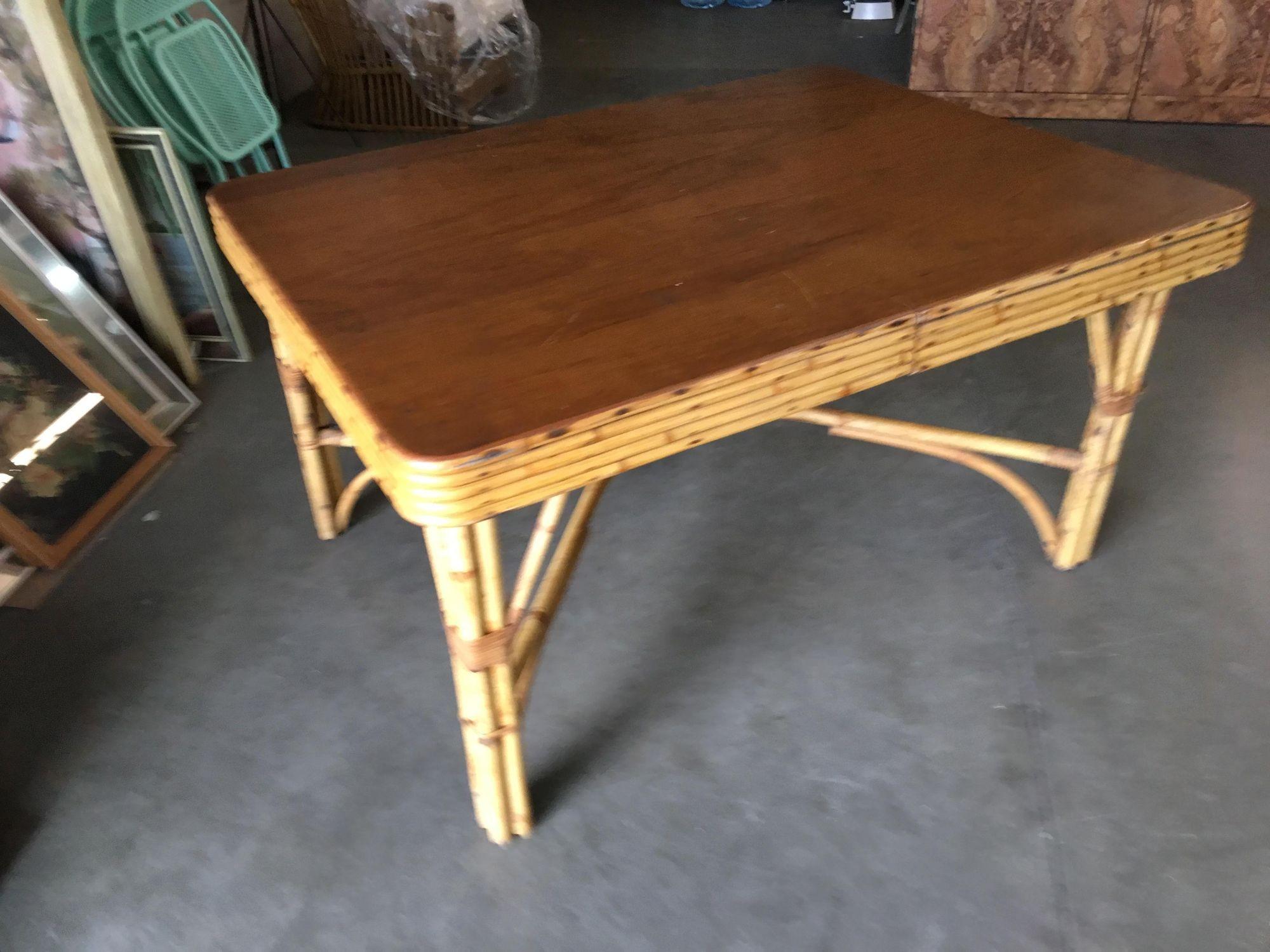 Midcentury era rectangle rattan dining table featuring a unique X-leg base made with a large mahogany rectangle top finished with 5-strand rattan trim.

We only purchase and sell only the best and finest rattan furniture made by the best and most