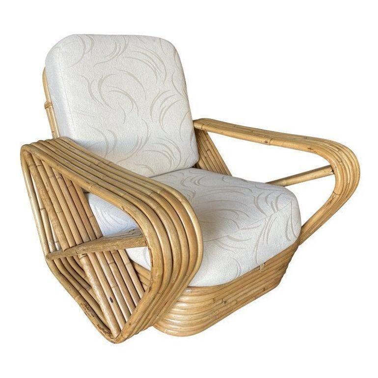 Designed in the manner of Paul Frankl, this six-strand rattan lounge chair features square pretzel arms and a Classic stacked base. Included is the matching stacked rattan ottoman. 

Lounge chair: 34