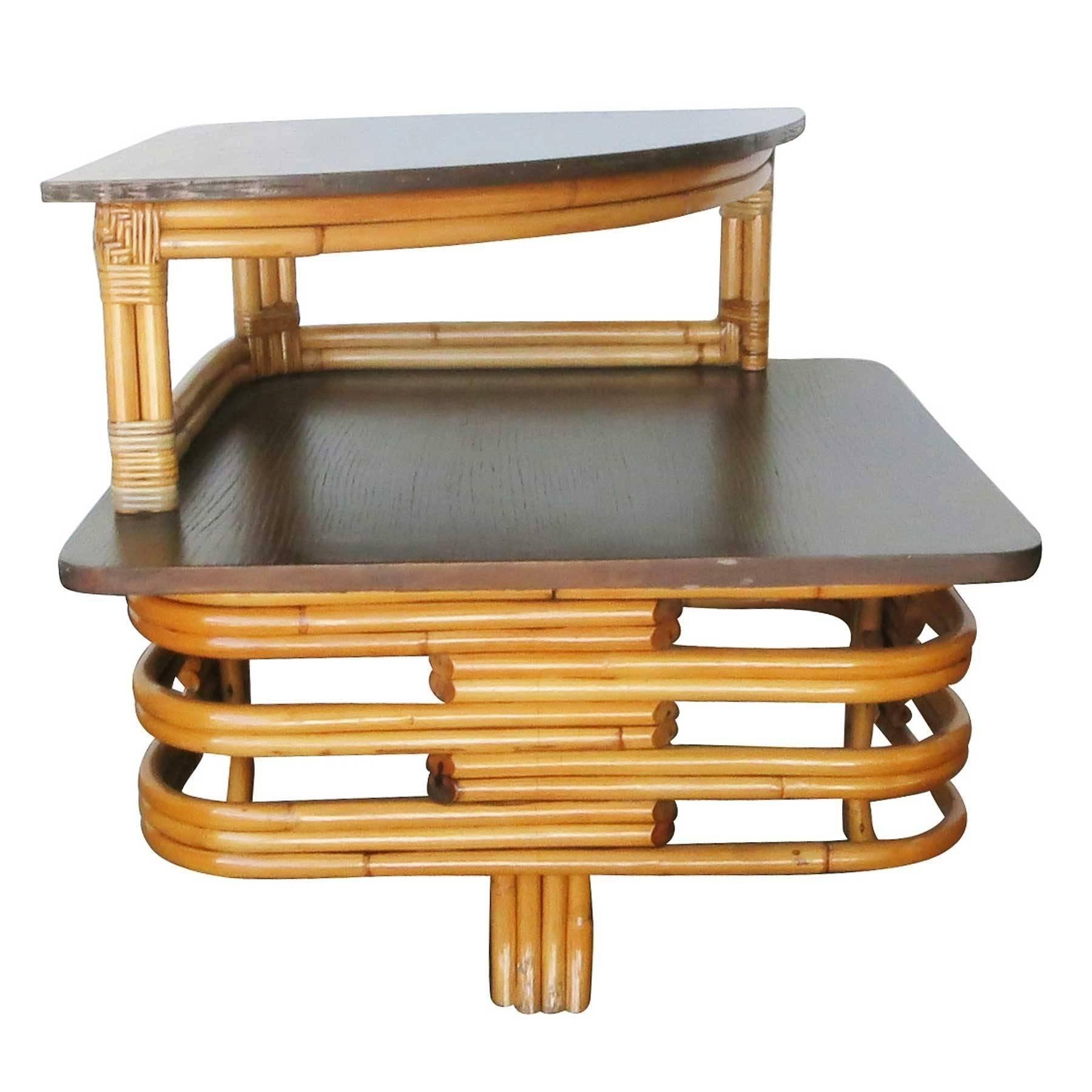 Vintage stacked cut-out rattan two-tier corner side table with a mahogany top.
1950, United States
We only purchase and sell only the best and finest rattan furniture made by the best and most well-known American designers and manufacturers