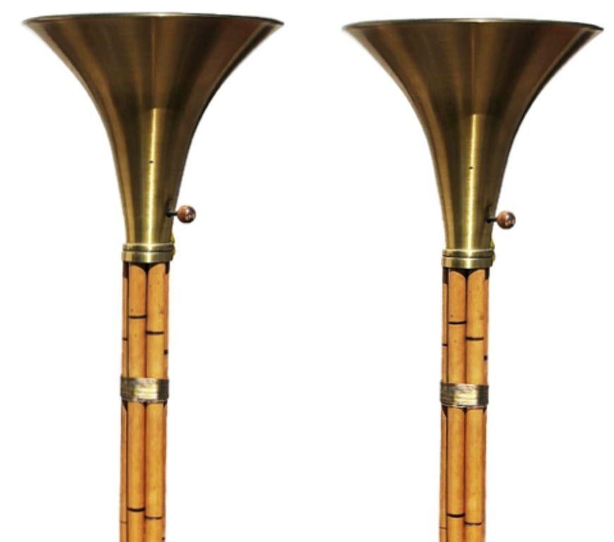 Restored Russel Wright Designed Brass and Rattan Mid-century torchère floor lamps. Crafted with 6 stacked rattan poles mounted to a brass base with brass wrappings and topped off with a spun aluminum brass Plated shade, this set combines Mid-century