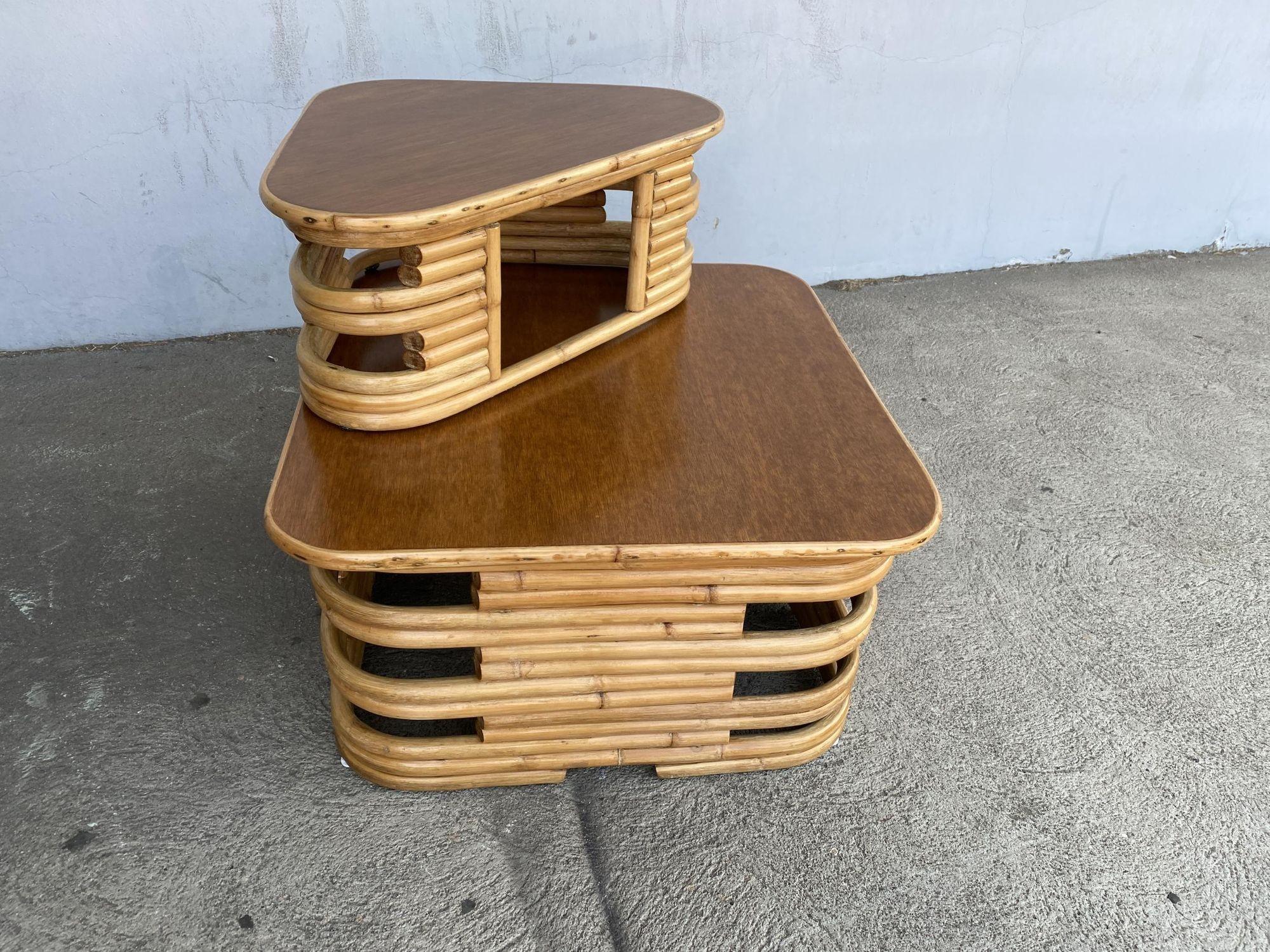 Fully restored rattan corner side table with mahogany tops and a second removable top. The table features a stacked rattan base with cut-outs along the corners and a mahogany top resting on top with a hand-formed rattan border along the table top's