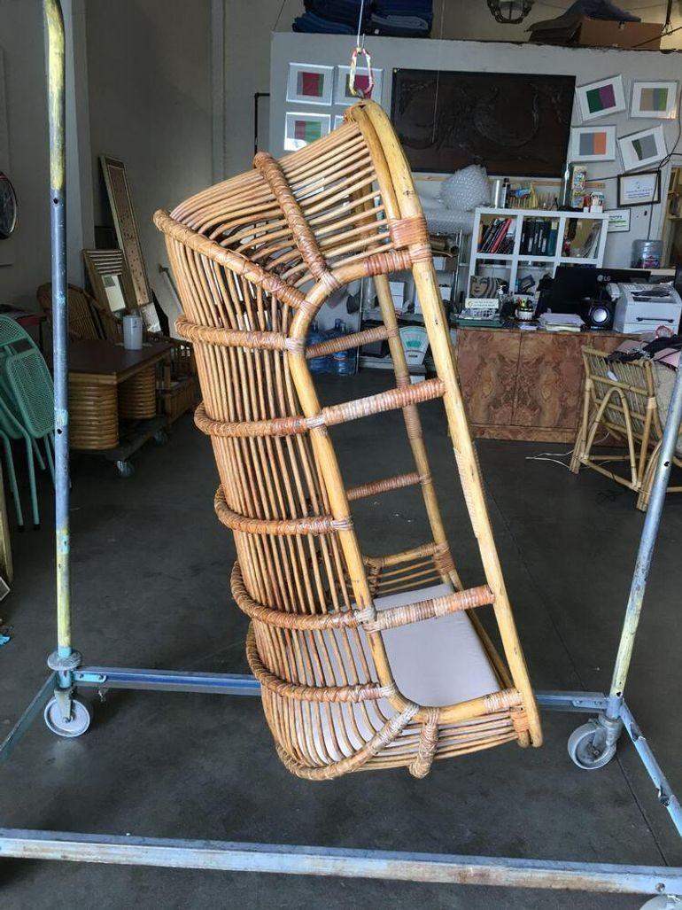 Original 1970s hanging stick rattan swing chair with arched top and rounded back.
Restored to new for you.
1950, United States
We only purchase and sell only the best and finest rattan furniture made by the best and most well-known American