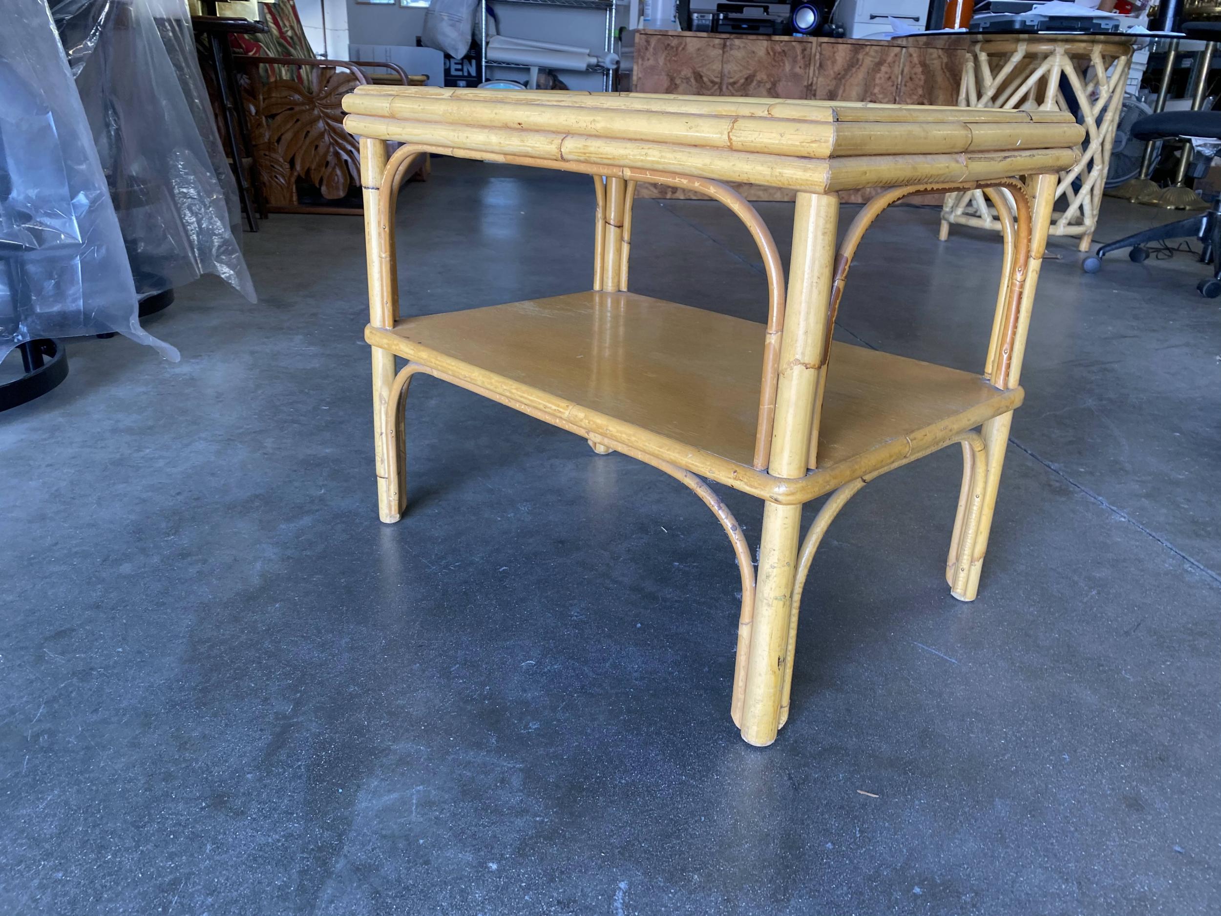 Original 1950s pole rattan rectangle coffee table with decorative stick rattan arches topped with a ripped frosted glass top. The table feature a Two-Tier design with a Mahogany bottom shelf for storage of magazines, e-readers, Remotes or anything