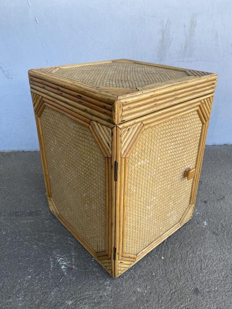 Post War modern woven wicker and stick rattan box with woven wicker sides and a single cabinet door along the front. Passt the door are two small 10