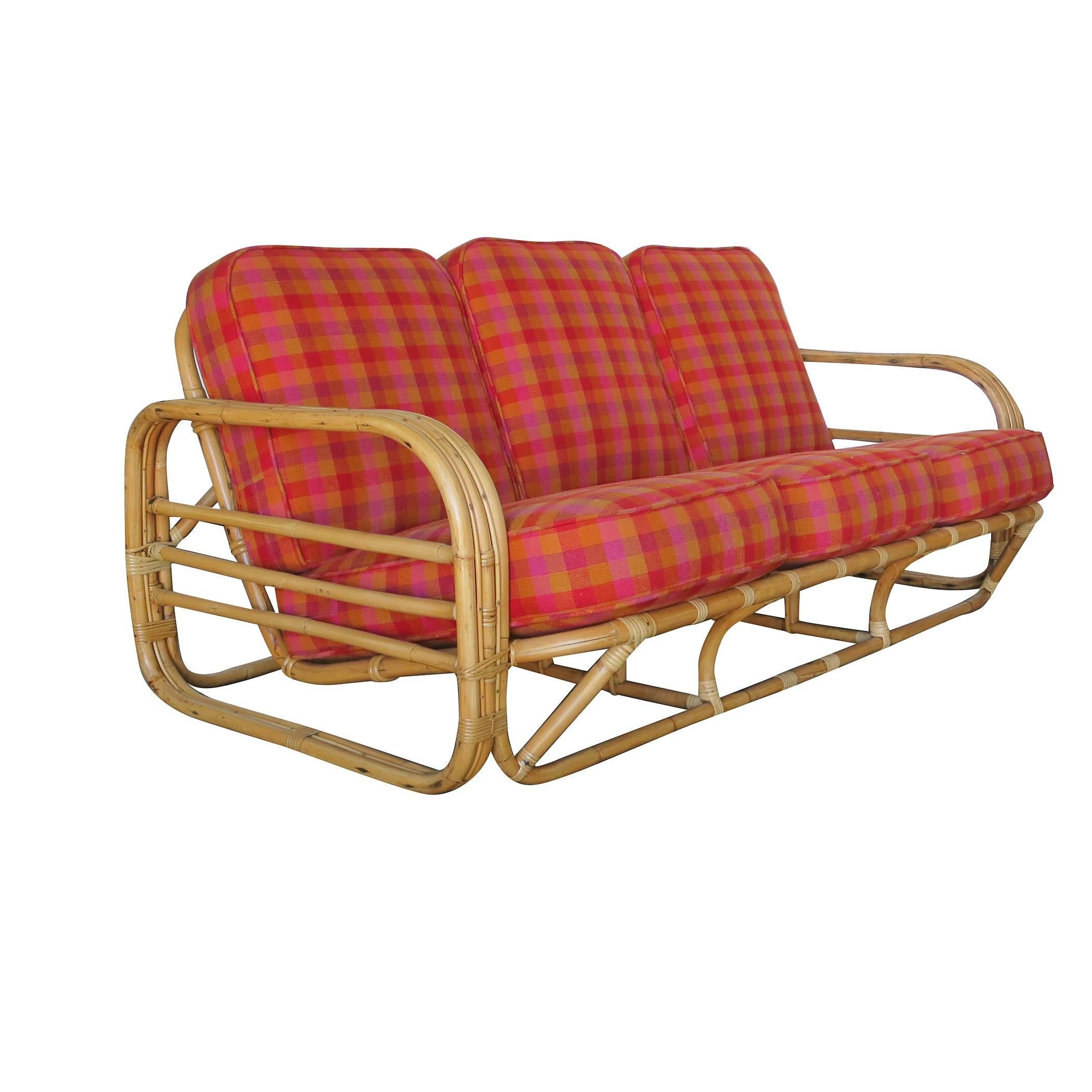 Streamline Art Deco rattan living room set which includes one lounge chair and a matching three-seat sofa.

Each seat features rounded three strand rattan arms with three decorative horizontal bars running through the center of each arm along with