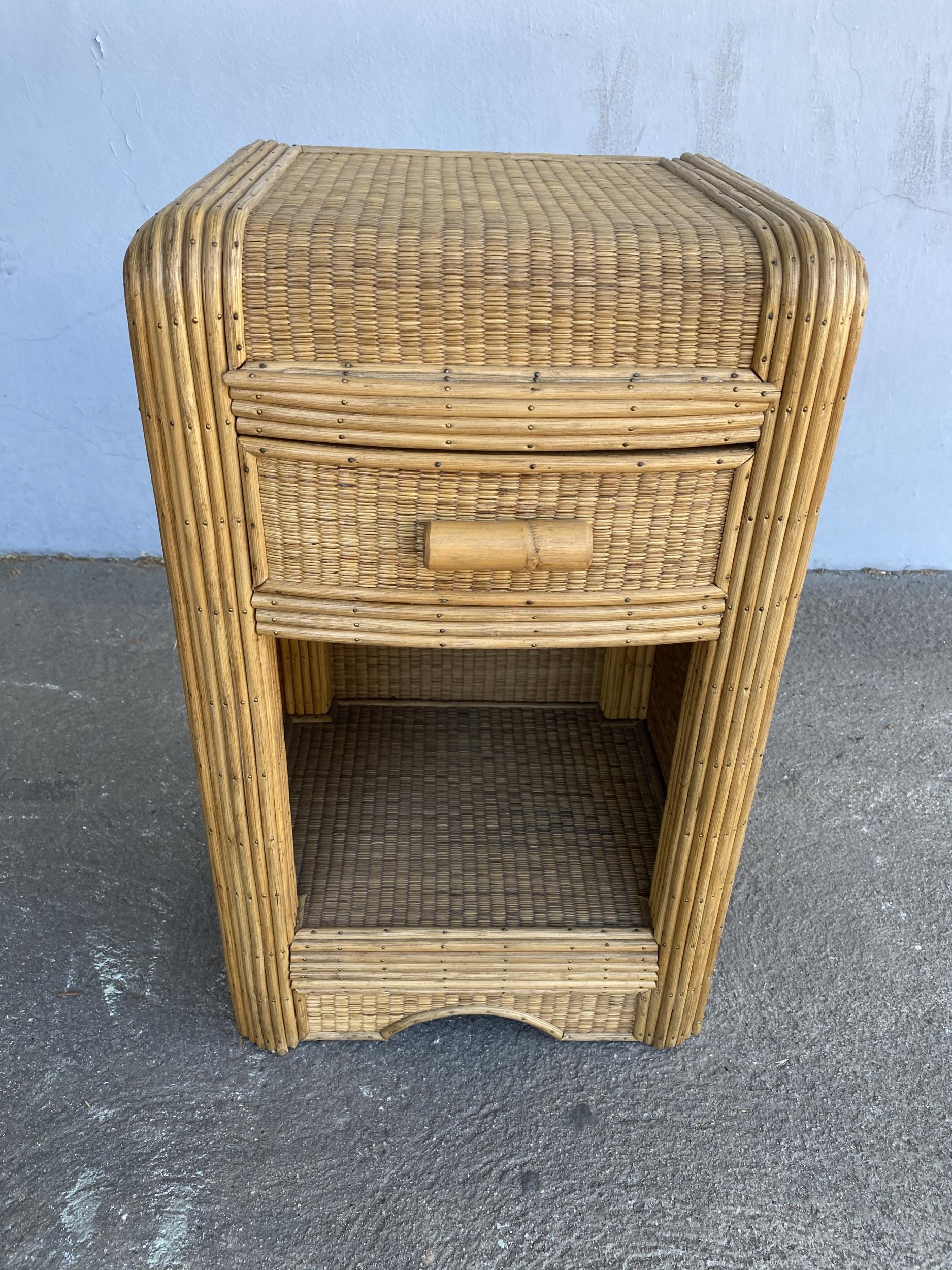 Streamline stick rattan side table with grass-mat coverings, a Rattan pull handle, and edges are finished with brass nails.

Designed in the manner of Paul Frankl.

Restored to new for you.

All rattan, bamboo and wicker furniture has been