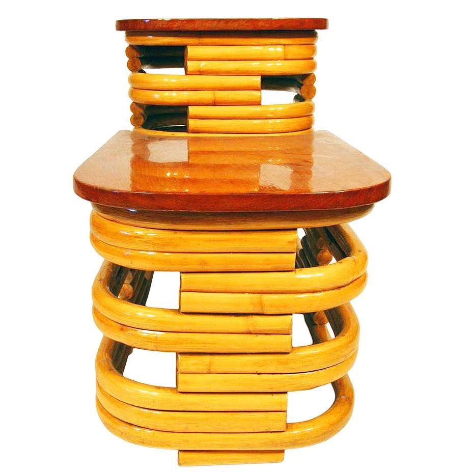 Beautifully restored 1940s two-tier stacked rattan side table with stylized cut-out sides and beautiful mahogany tops on both tiers. The stunning table is designed in the manner of Paul Frankl.

Sale for 1 Table, 2 Available

The table blends style