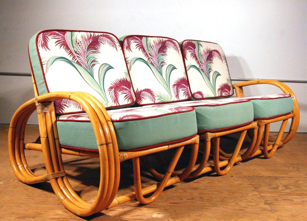Three-strand 3/4 reverse pretzel arm rattan sofa features a decorative wave detail on both sides of the base. Reminiscent of the sofas done by Paul Frankl in the 1940s.

Restored to new for you.

This was made by Ritts co, Tropitan , Herb Sr.