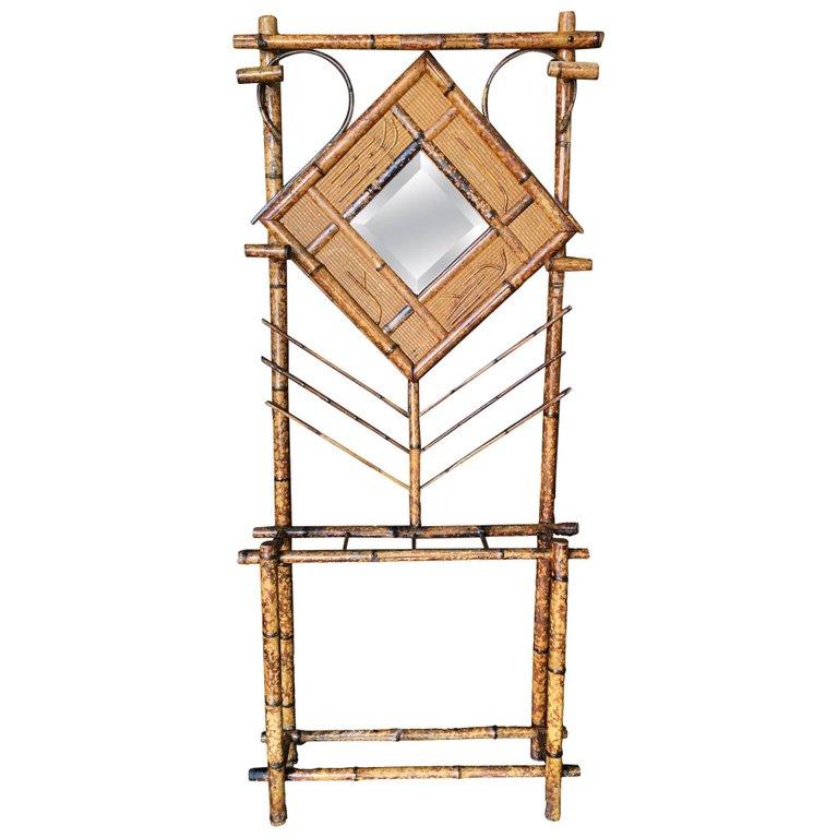 Antique tiger bamboo hall tree with handwoven rice mat and decorative square/diamond center piece. The hall tree features three slots for storing umbrellas and a vanity mirror and four hooks for coats.

Restored to new for you.

All rattan, bamboo
