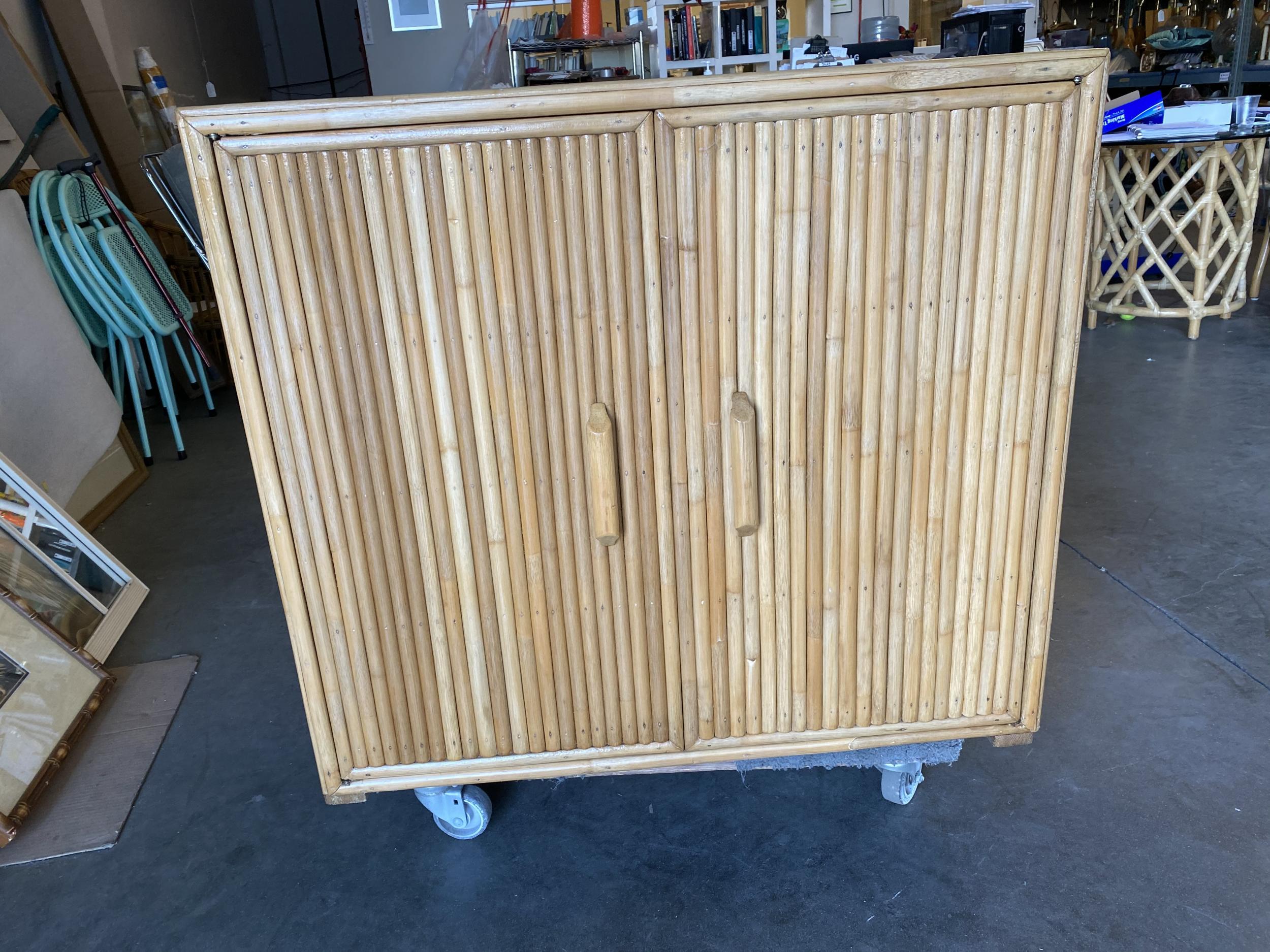 Vertically stacked rattan lowboy cabinet with a solid mahogany top. The cabinet features double doors and two adjustable shelves. 

Restored to new for you.

All rattan, bamboo, and wicker furniture has been painstakingly refurbished to the highest