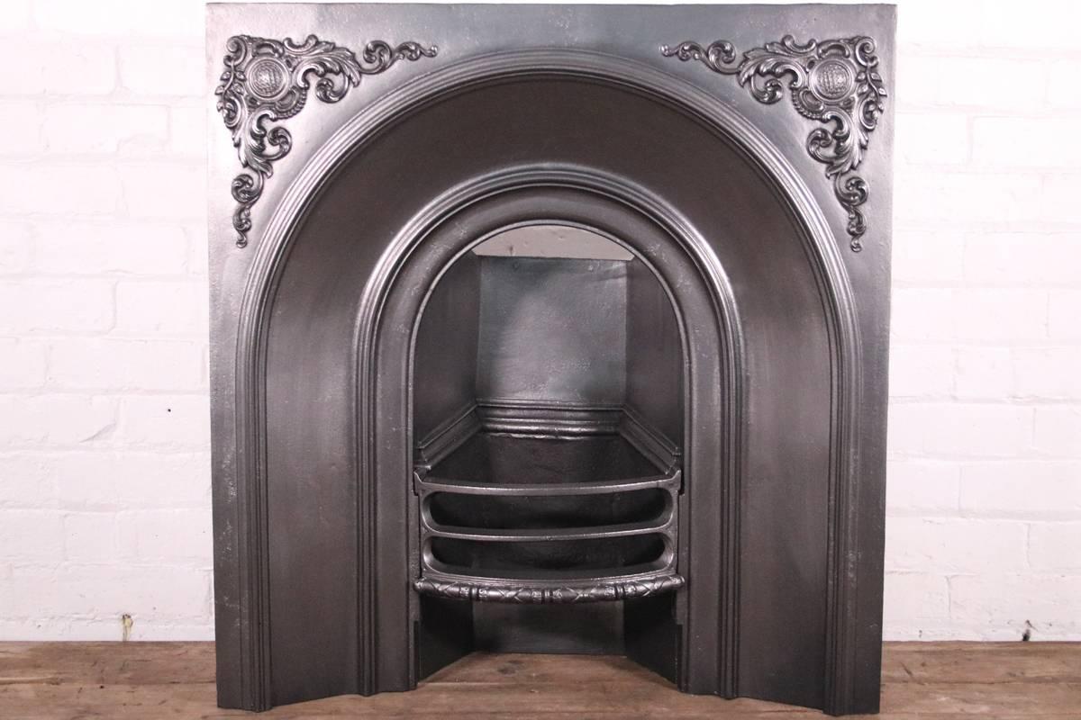 Restored Victorian cast iron fireplace insert with arched aperture and good detail to the spandrels. Produced by the Carron foundry in Falkirk, Scotland, circa 1860. 

Finished with traditional black grate polish, ready for a solid fuel fire.