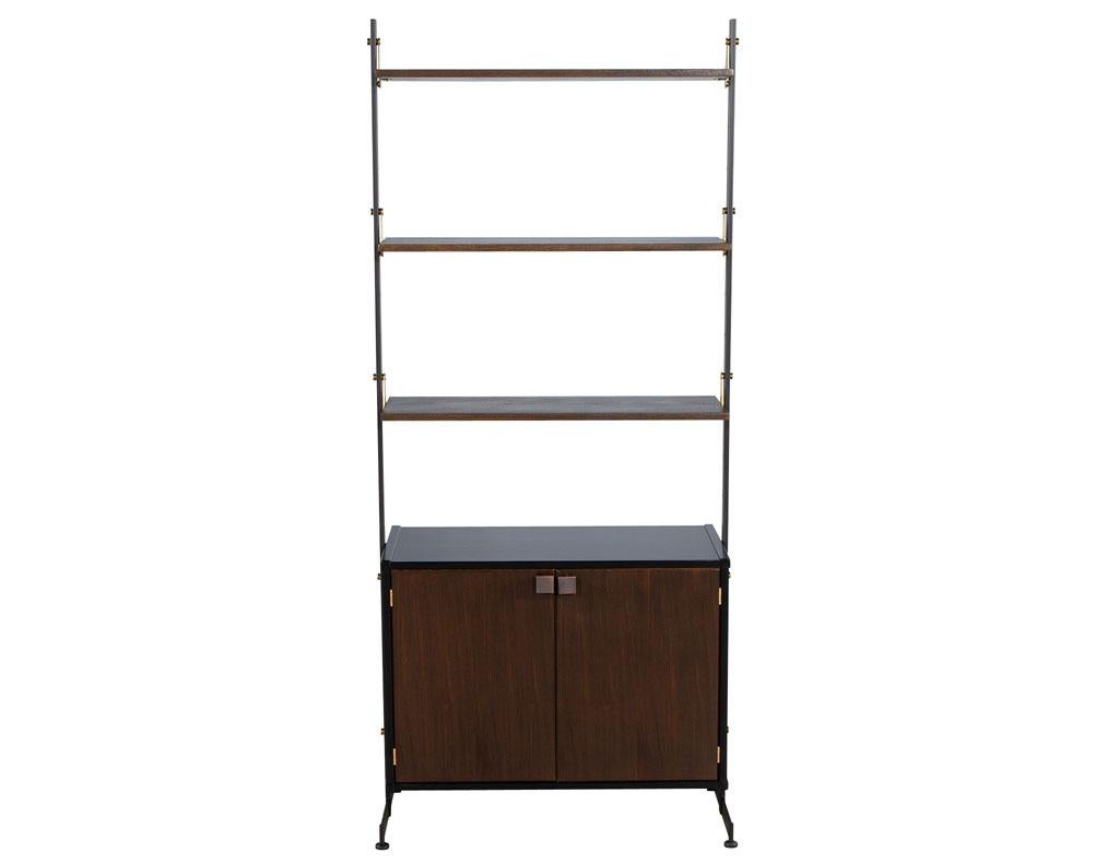 Restored vintage 1960’s Mid-Century Modern bookcase wall cabinet. Featuring brass detailed accents and walnut woods. Finished in a dark espresso brown, this piece is the perfect statement piece for any living room or home office space. Cabinet is