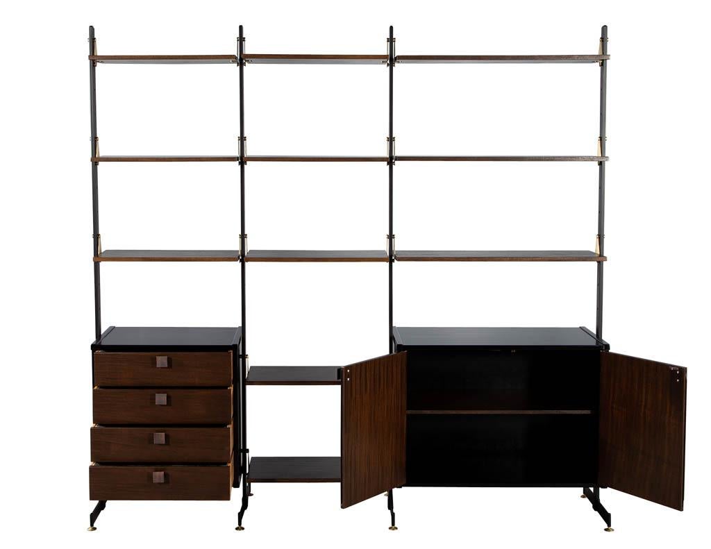 Restored Vintage 1960’s Mid-Century Modern wall unit display cabinet. Featuring brass detailed accents and walnut woods. Finished in a dark espresso brown, this piece is the perfect statement piece for any living room or home office space. Wall unit