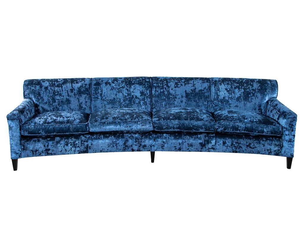 Restored Vintage blue velvet curved back sofa. Masterfully restored by the artisans at Carrocel in a luxurious crushed blue velvet with intricate details. Original curved mid-century design resting atop sleek satin black legs. This 4 seater is the