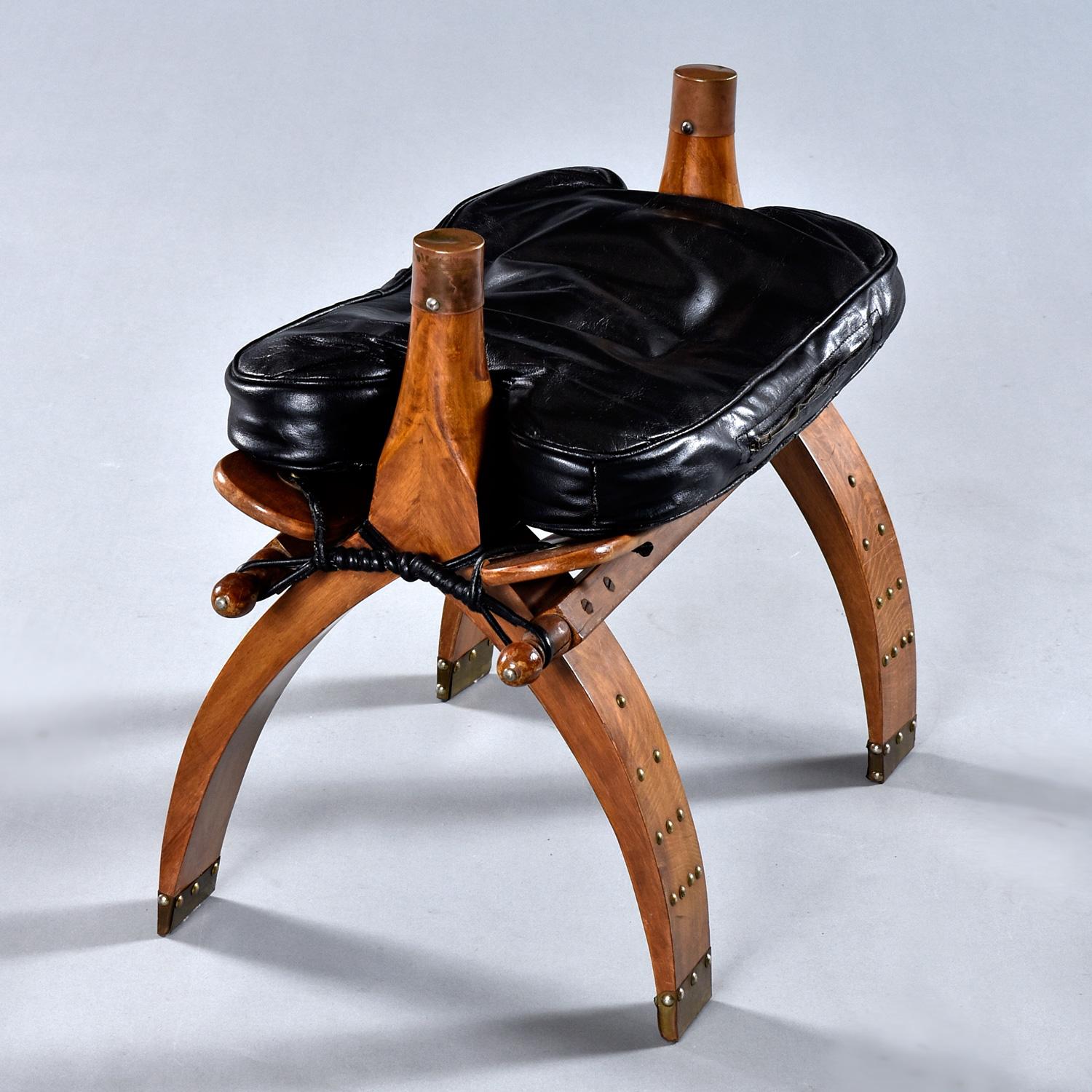 Our entire restoration team joined forces to bring this camel saddle back to its original glory. The Mid-Century era camel saddle can be used as a foot stool or ottoman. The well-loved stool came to us intact, but a bit worse for wear. One of the