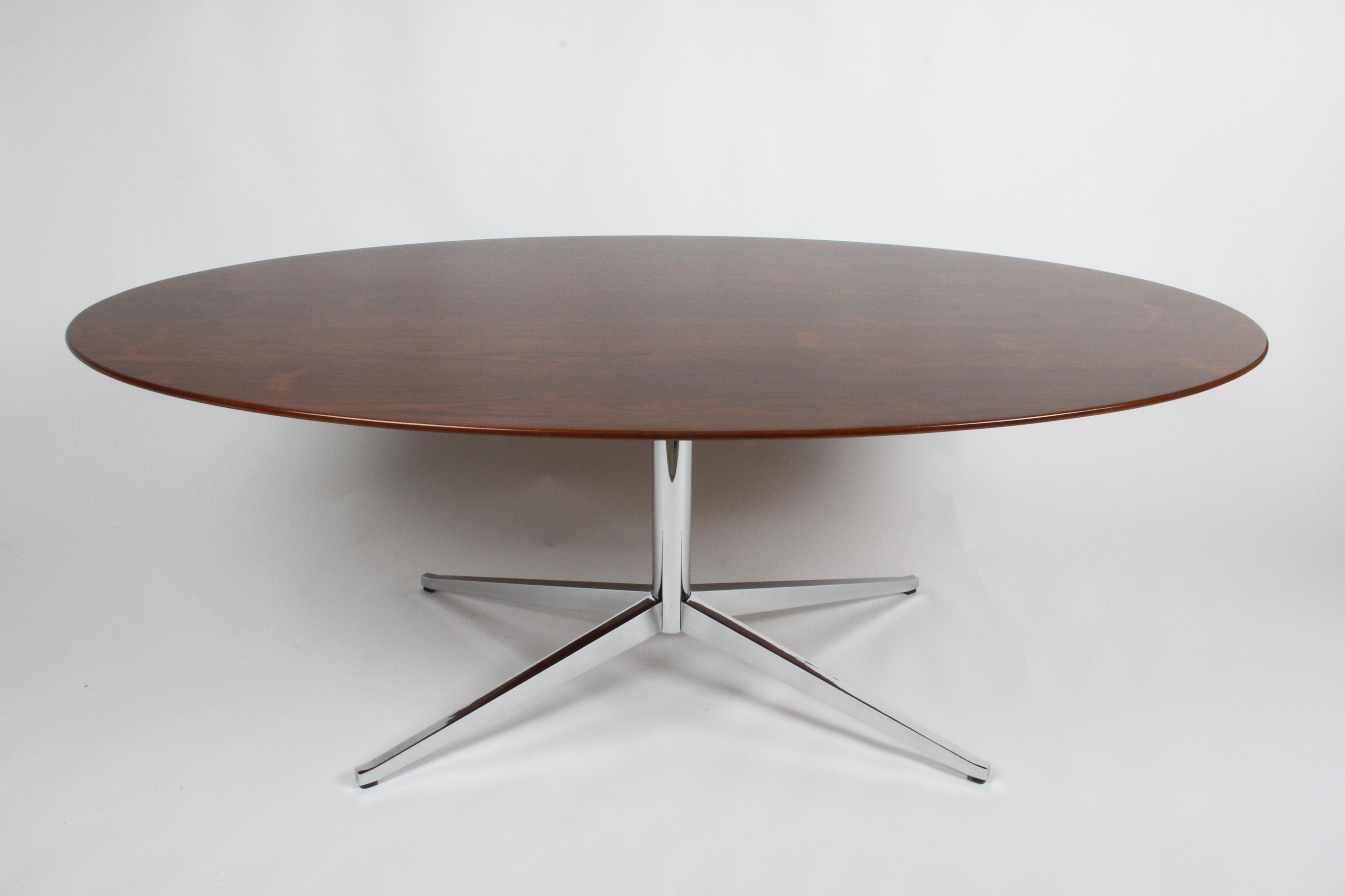 Restored Mid-Century Modern vintage Florence Knoll oval top dining table / conference or desk in rare book matched rosewood veneer on chrome star base. The rosewood has been refinished, the heavy steel chrome plated four legs have been re-chromed.