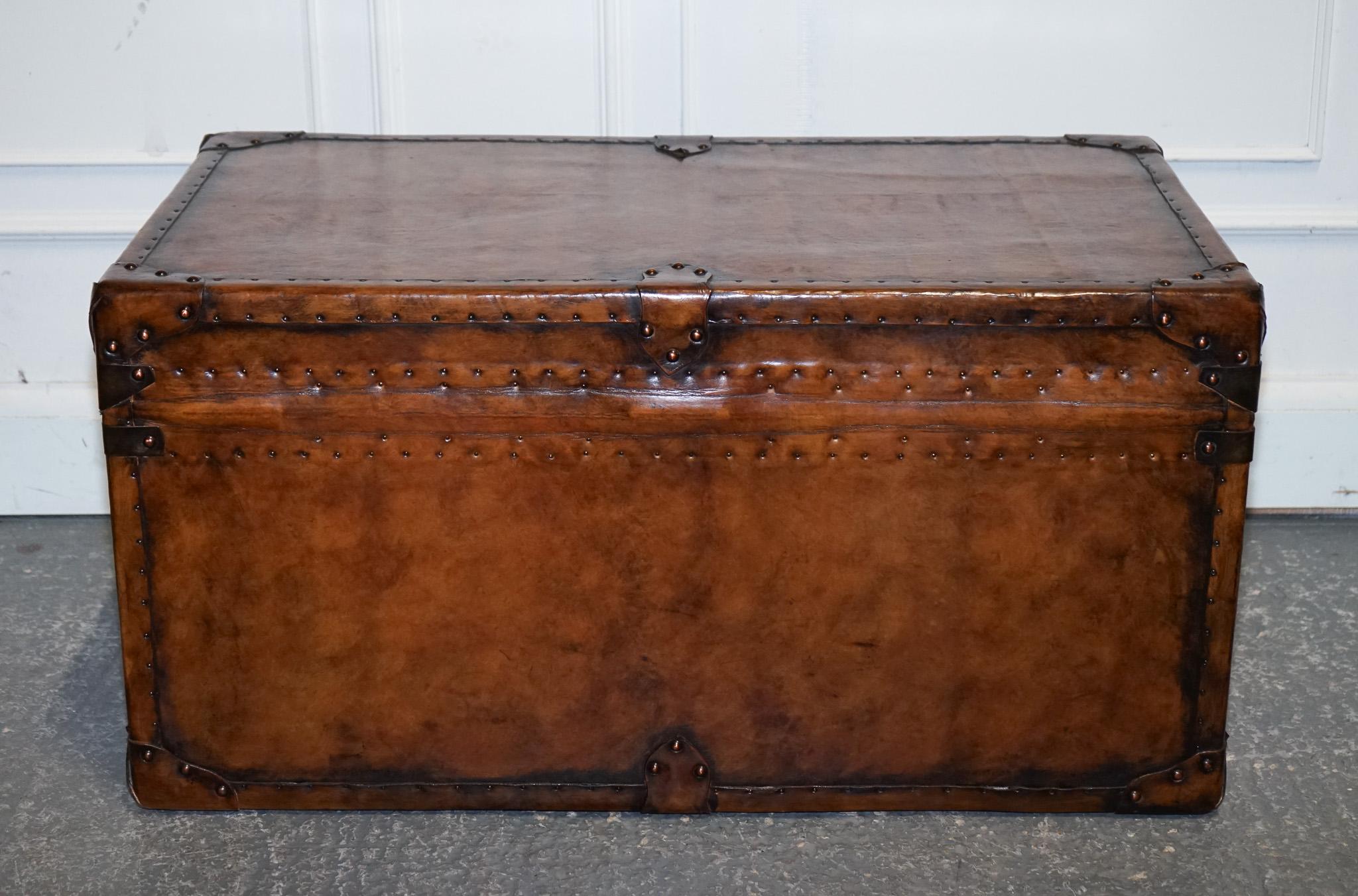 
Antiquités de Londres



Cette étonnante malle de rangement vintage à toit plat a été entièrement restaurée et finie en cuir marron teint à la main, ce qui lui confère une patine richement marbrée. Le processus de teinture à la main fait ressortir