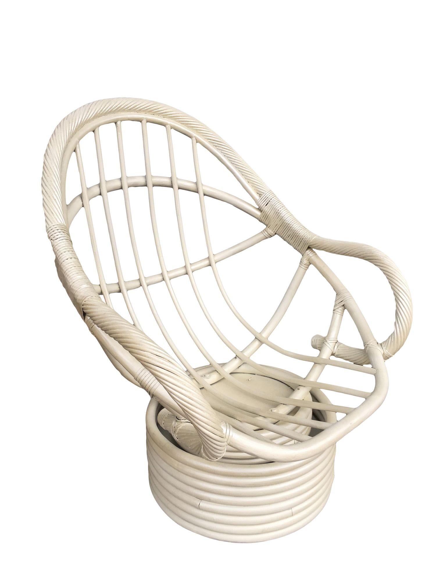 Classic rattan bucket seat featuring a circular height carved with two armrests fixed to a round stacked rattan swivel base. TThe chair has been repainted to its original white color and includes a yellow foam seat.

1970, United States

We only