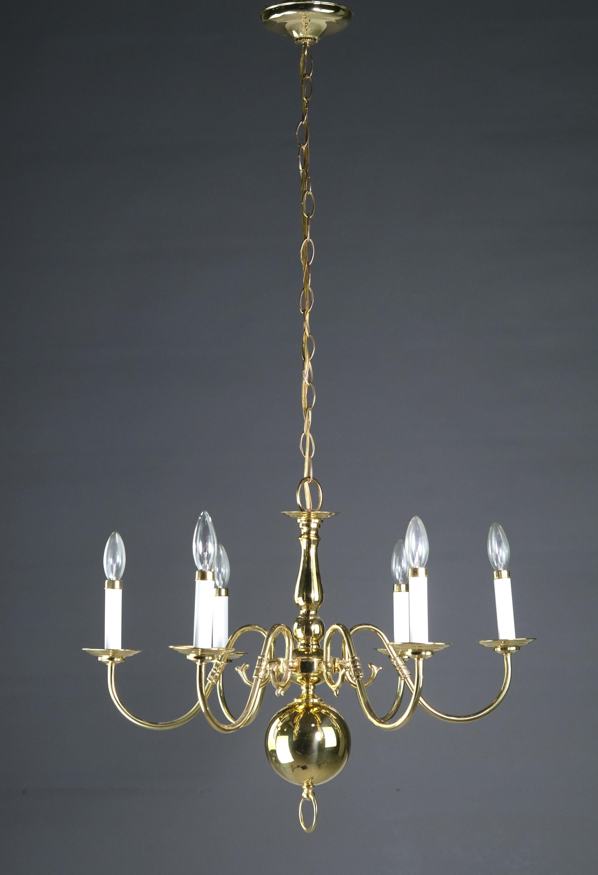 20th Century Williamsburg chandelier manufactured with a polished brass finish. Th six arms are arranged in a hexagon pattern. Takes six standard household candelabra lightbulbs. Cleaned and restored. Please note, this item is located in our
