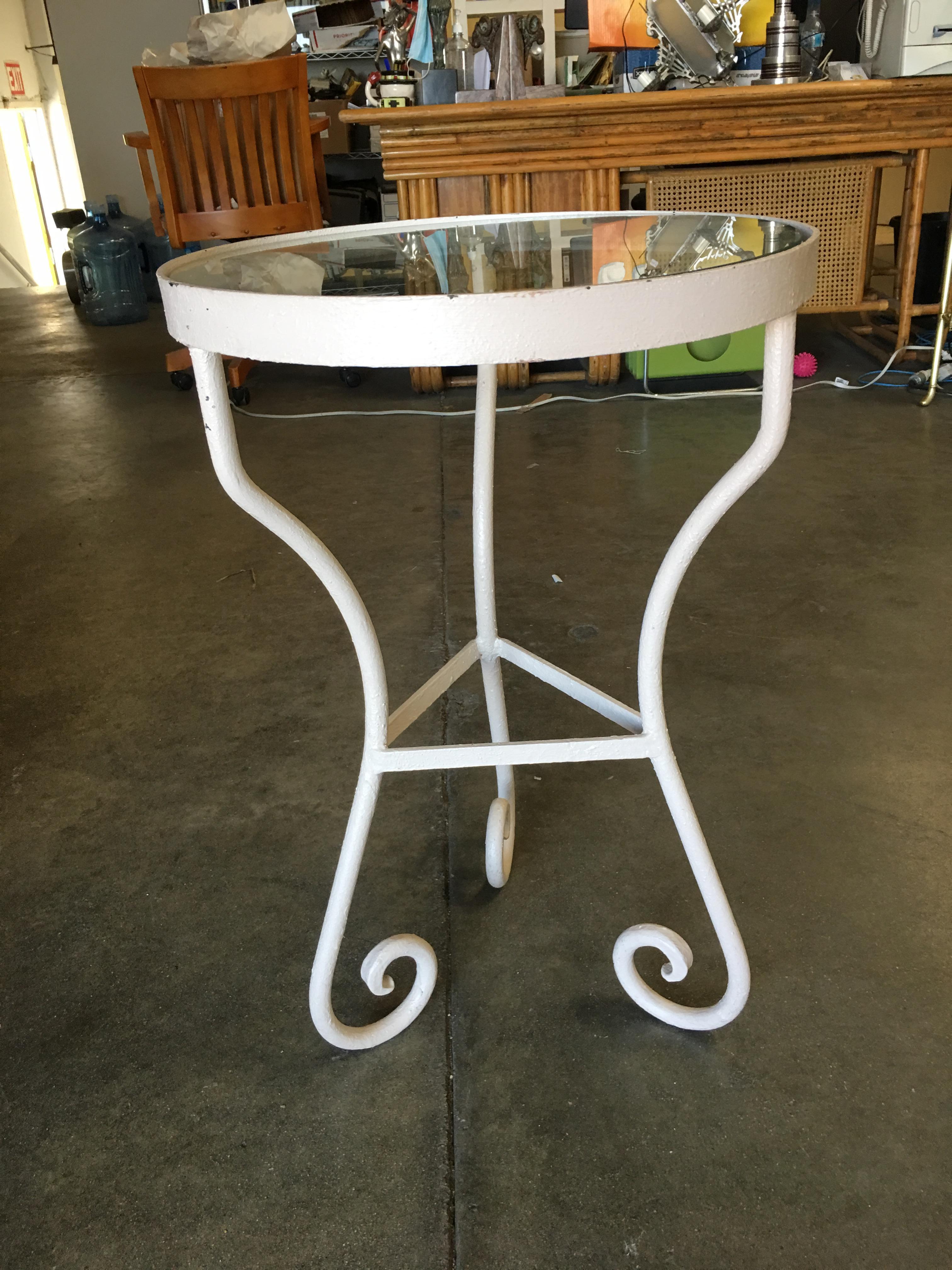 Vintage outdoor/patio side table with iron scrolling base and glass top by the Woodward company. The table can be repainted in your choice of black, teal or white.

Circa 1950, USA by Woodard.

