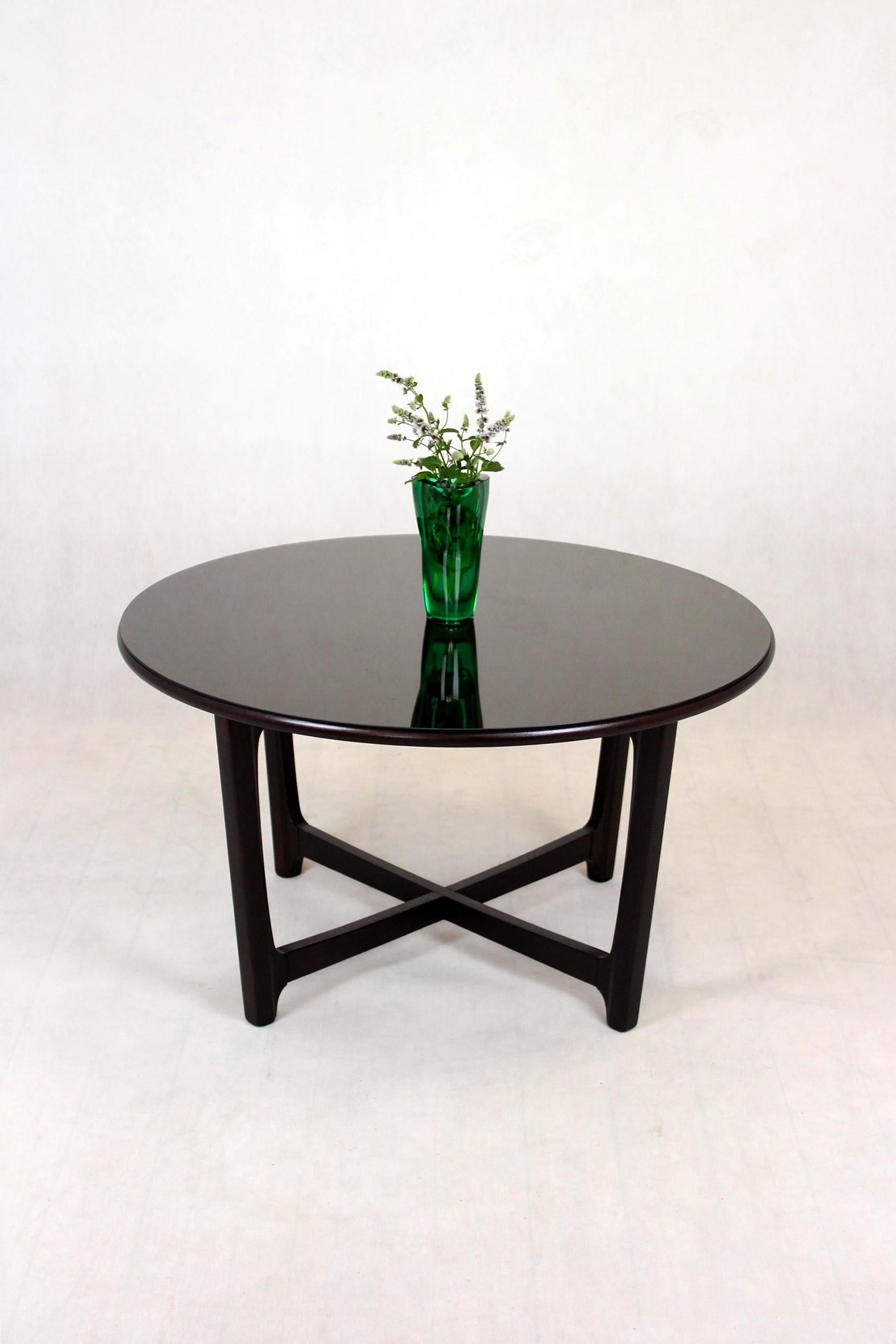 This round coffee table was made in Czechoslovakia in the 1970s. The table has been restored, lacquered in a satin finish. There is also a glass on the top (original from the 1970s, with visible scratches), which can be easily removed.
