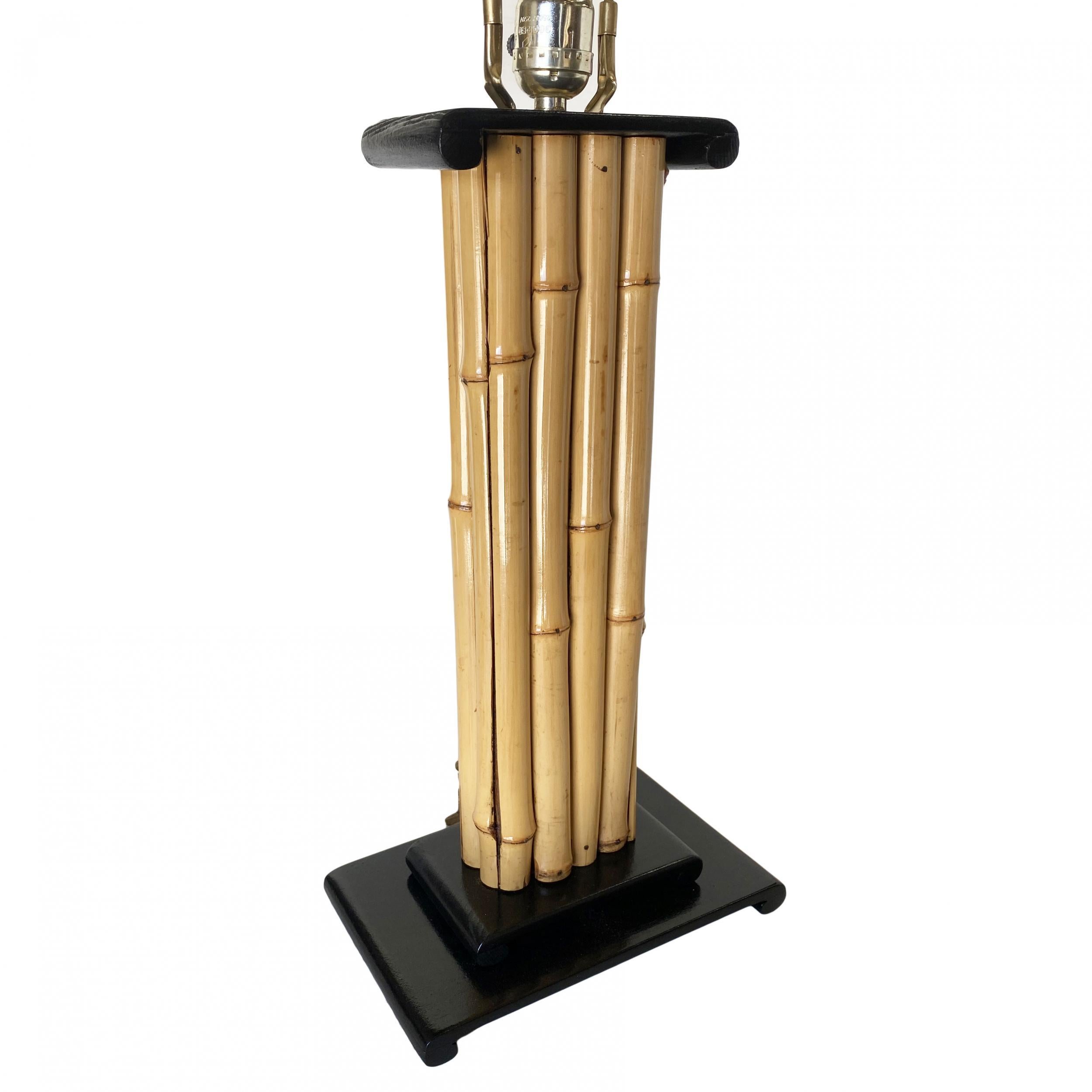 Vertically stacked rattan pole lamp with black lacquer demi mahogany base and top cap piece.

Restored to new for you.

All rattan, bamboo, and wicker furniture has been painstakingly refurbished to the highest standards with the best materials. All