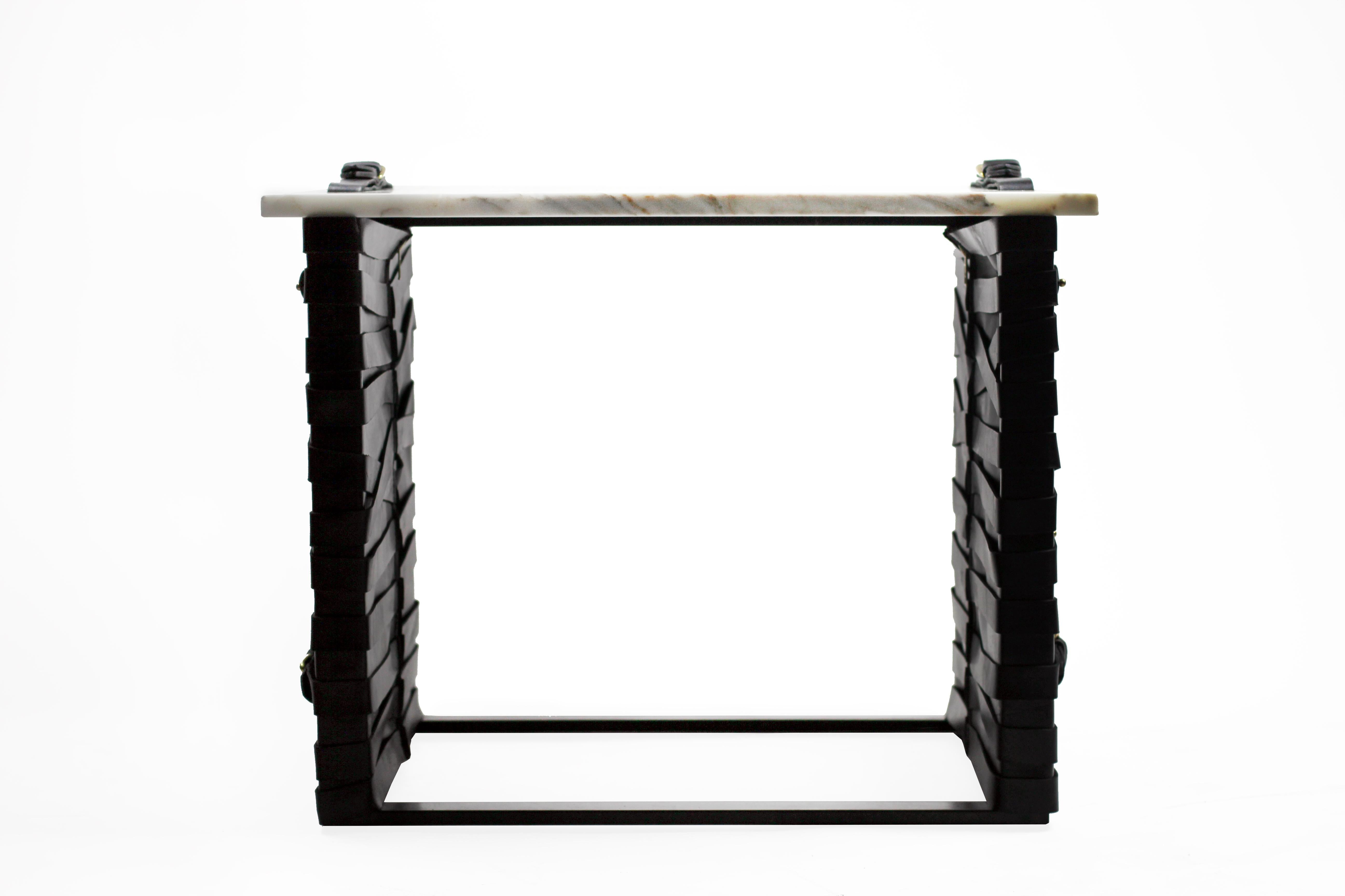 The (wh)ORE HAüS STUDIOS restraint accent table is made of blackened steel, marble, brass accents and leather panels. This table is made to order and can, therefore, be customized. As pictured, blackened steel, Calacatta gold marble and black