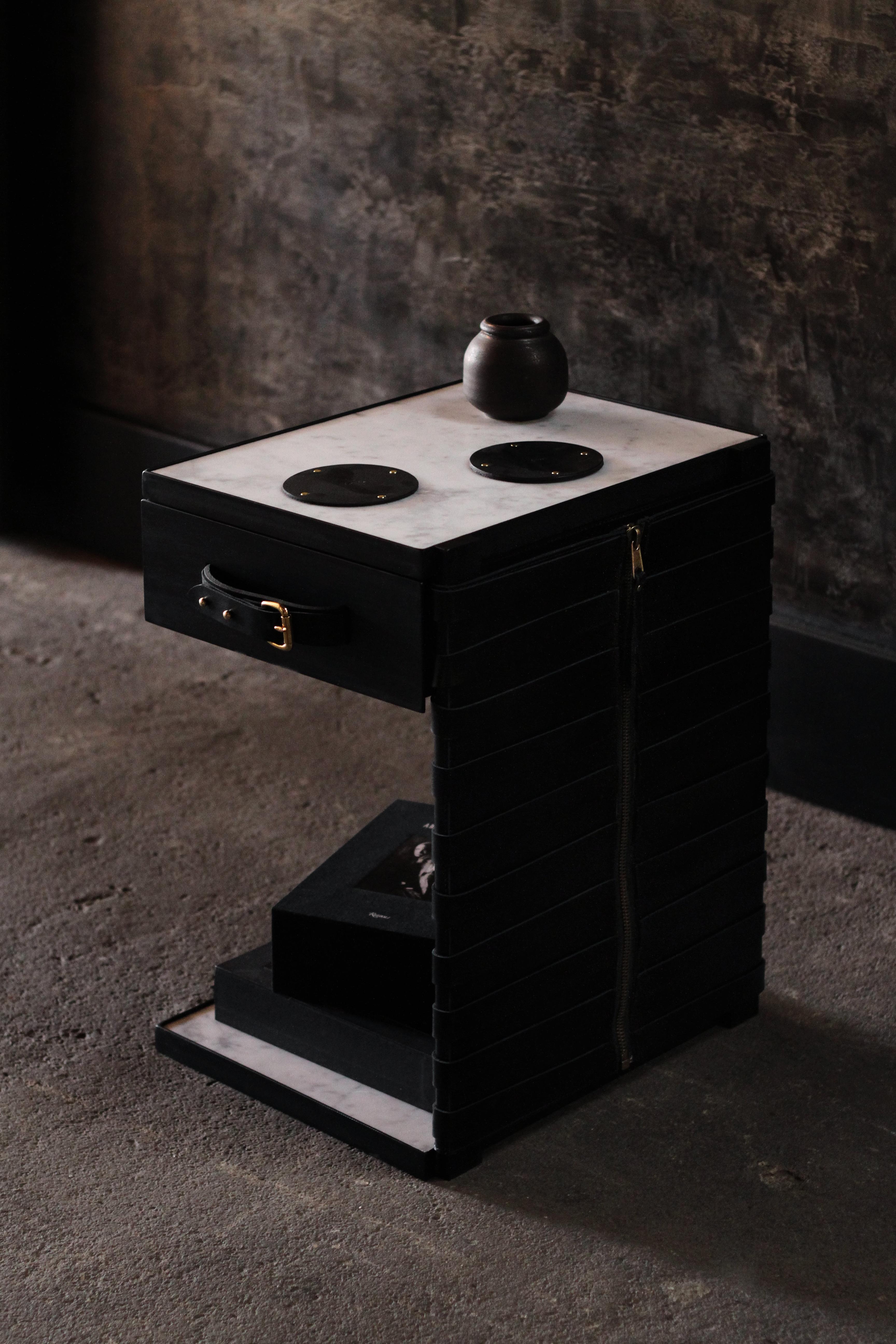 The (wh)ORE HAüS STUDIOS Restraint side table is made of blackened steel, marble, brass accents and leather panels. This table is made to order and can, therefore, be customized. As pictured; Blackened steel, Nero Marquina marble, and black leather