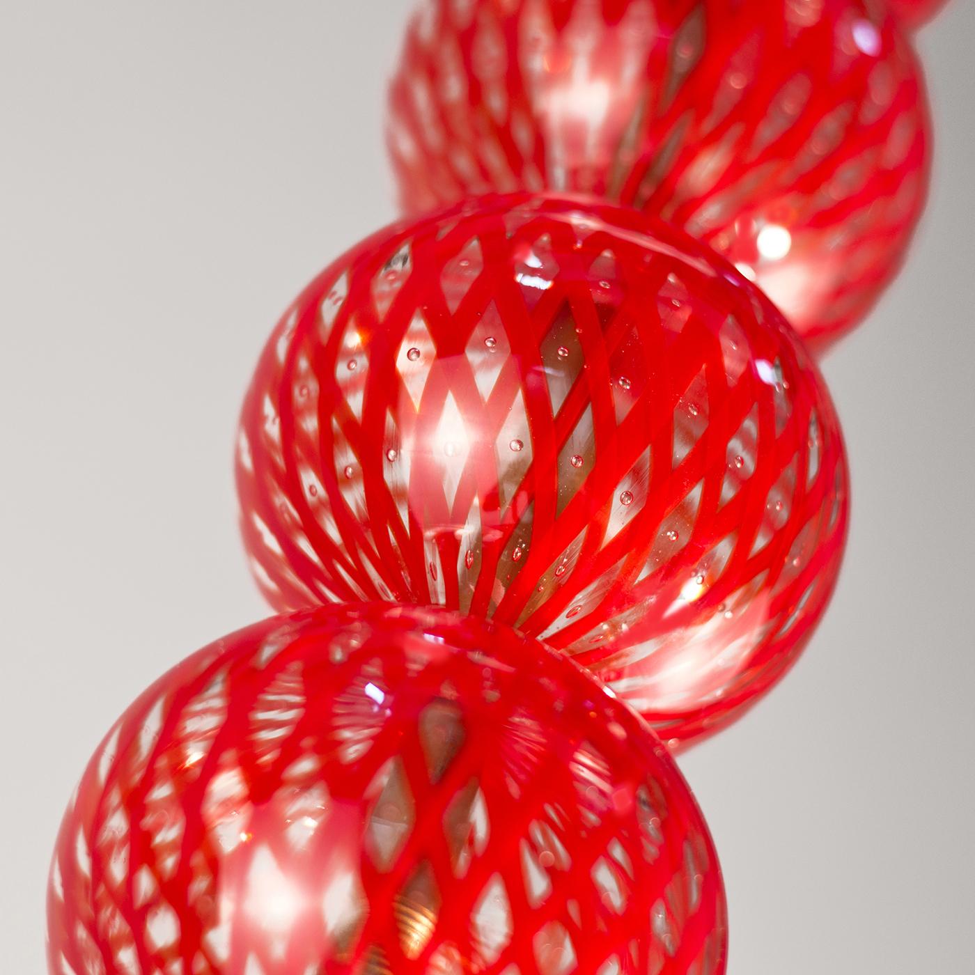 Inspired by the 1920s Venetian trend of glass vegetables and fruit, this chandelier is inspired by gooseberries. With a Minimalist design for contemporary homes, the glass spheres are made in red and transparent glass using the reticello technique