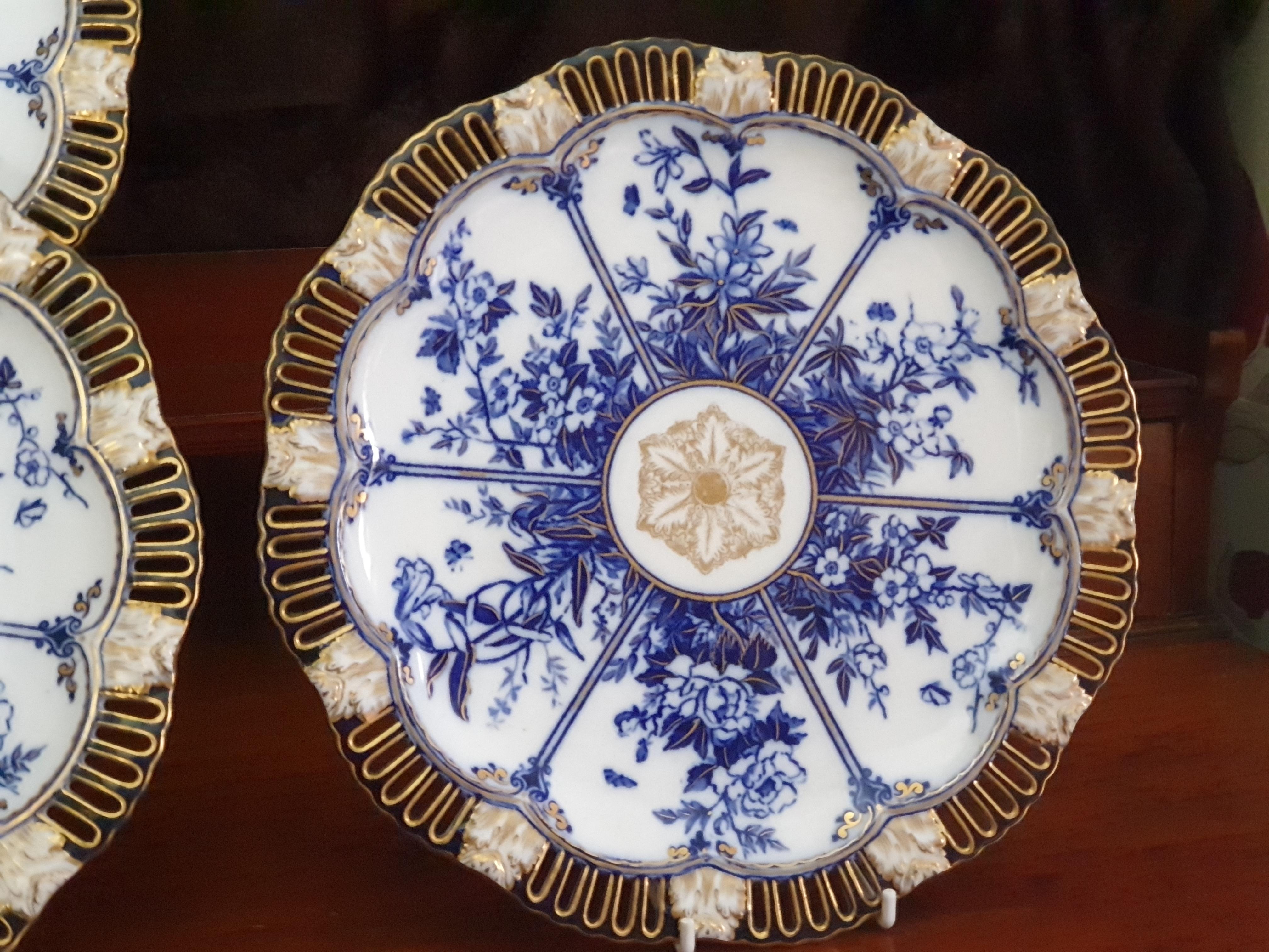 Un set di 4 imponenti piatti reticolati di Coalport decorati in bianco e blu con doratura a 24 carati, scena floreale a pannelli con fiori di loto al centro, inizio del XIX secolo.