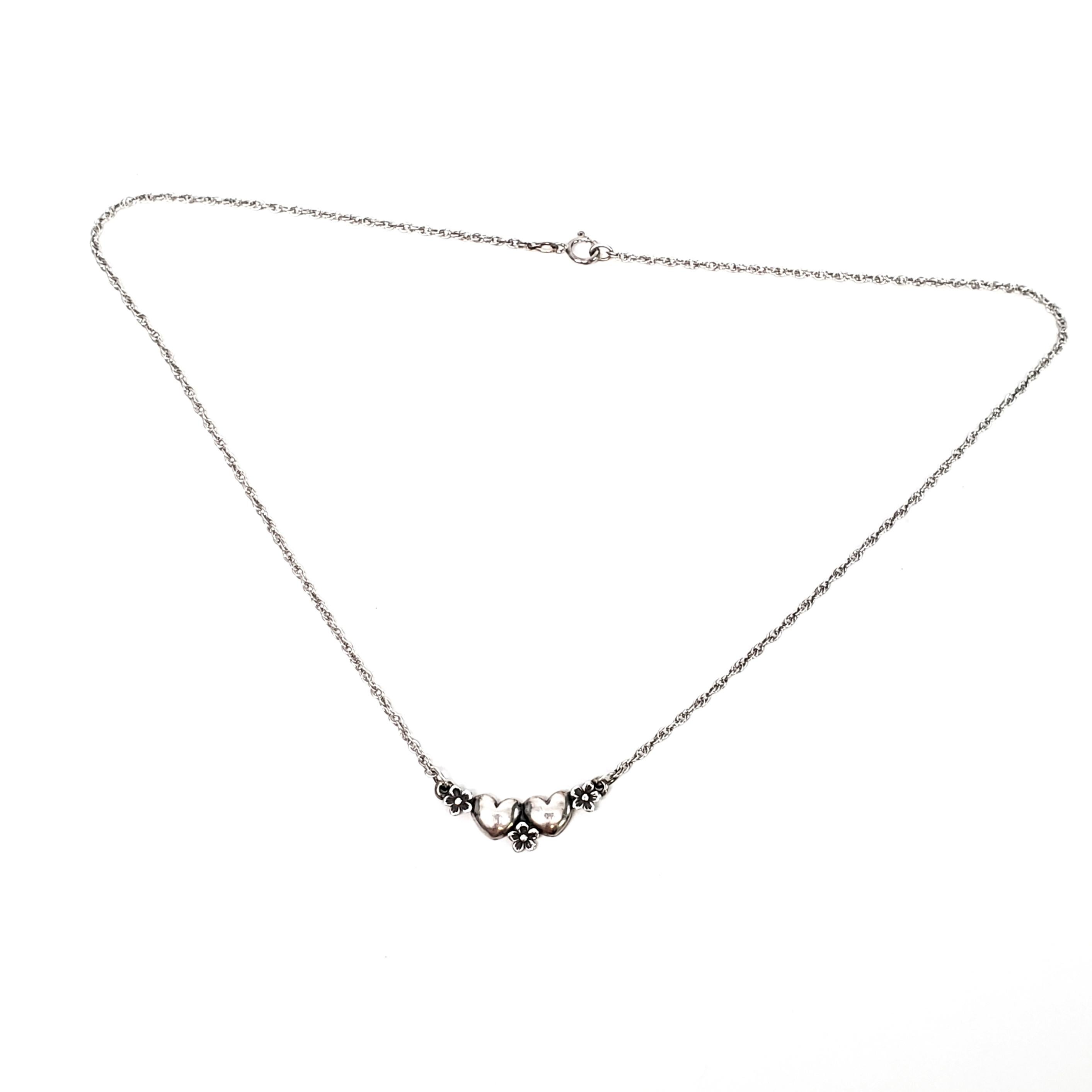 James Avery sterling silver Hearts and Flowers necklace.

Sweet and delicate necklace featuring double hearts with three small flowers on a chain necklace.

Matching bracelet also available in separate listing (#6994)

Measures 16